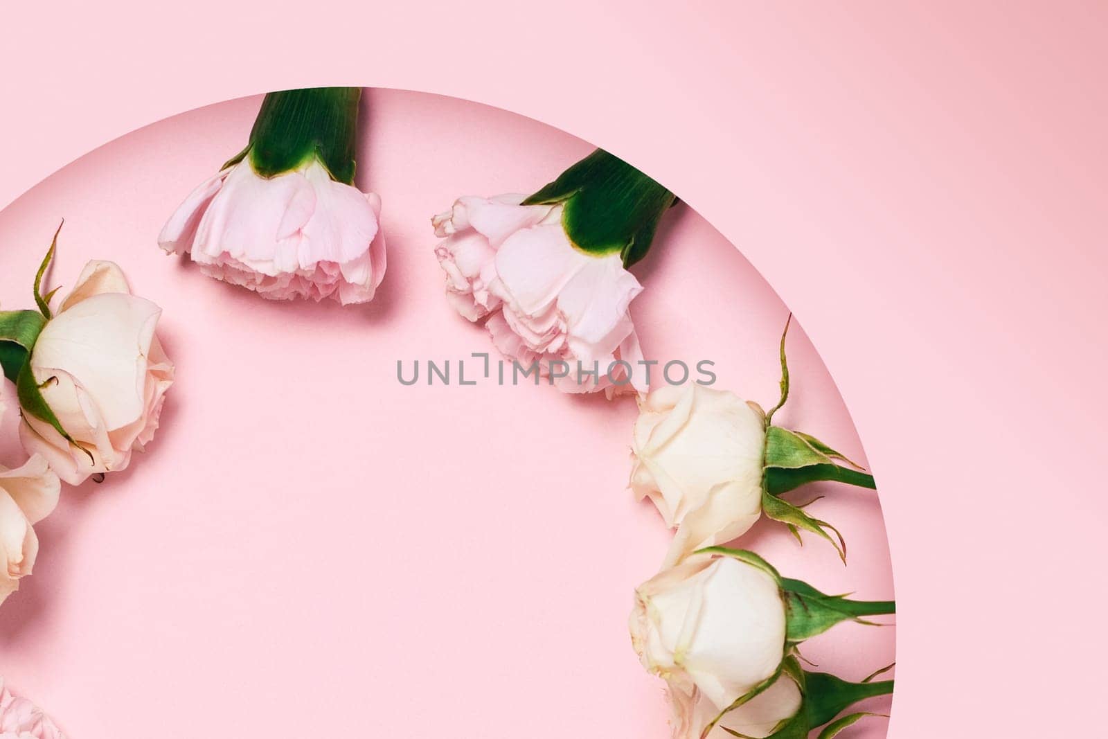 Festive greeting card with a bouquet of roses lying on a carved background paper.