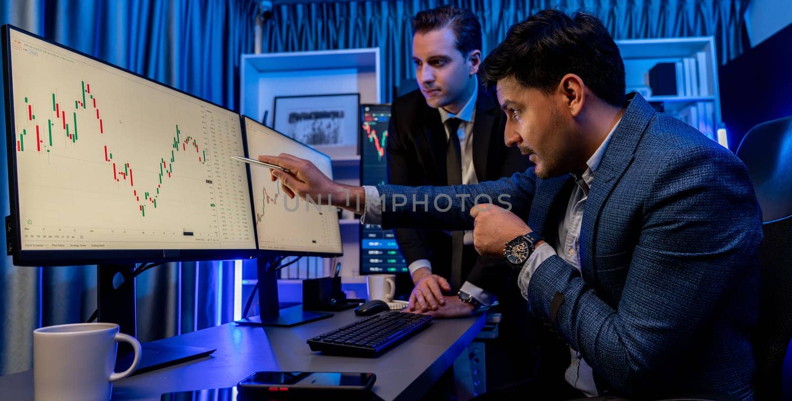 Stock exchange traders looking on high profit chart investment in panorama view, analyzing on monitor at night. Concept of discussing financial technology growth in neon light at workplace. Sellable.