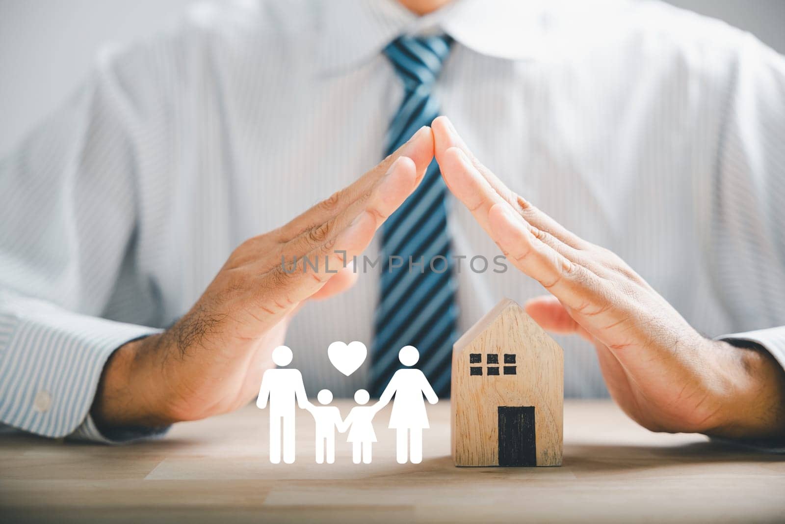 Insurance, safeguarding families and security. Businessman with protective gesture by family silhouette. Icons for family, life, health, and house insurance. Conveying insurance concept.