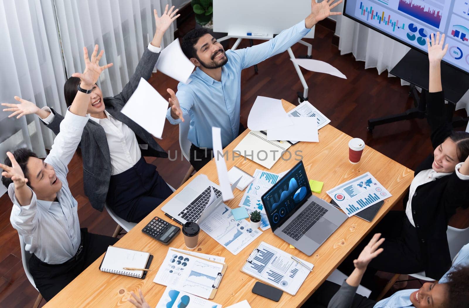 Top view office worker celebrate in meeting room, throwing paperwork in the air. Excitement and freedom expression from business people throw analysis financial paper in celebratory gesture. Concord