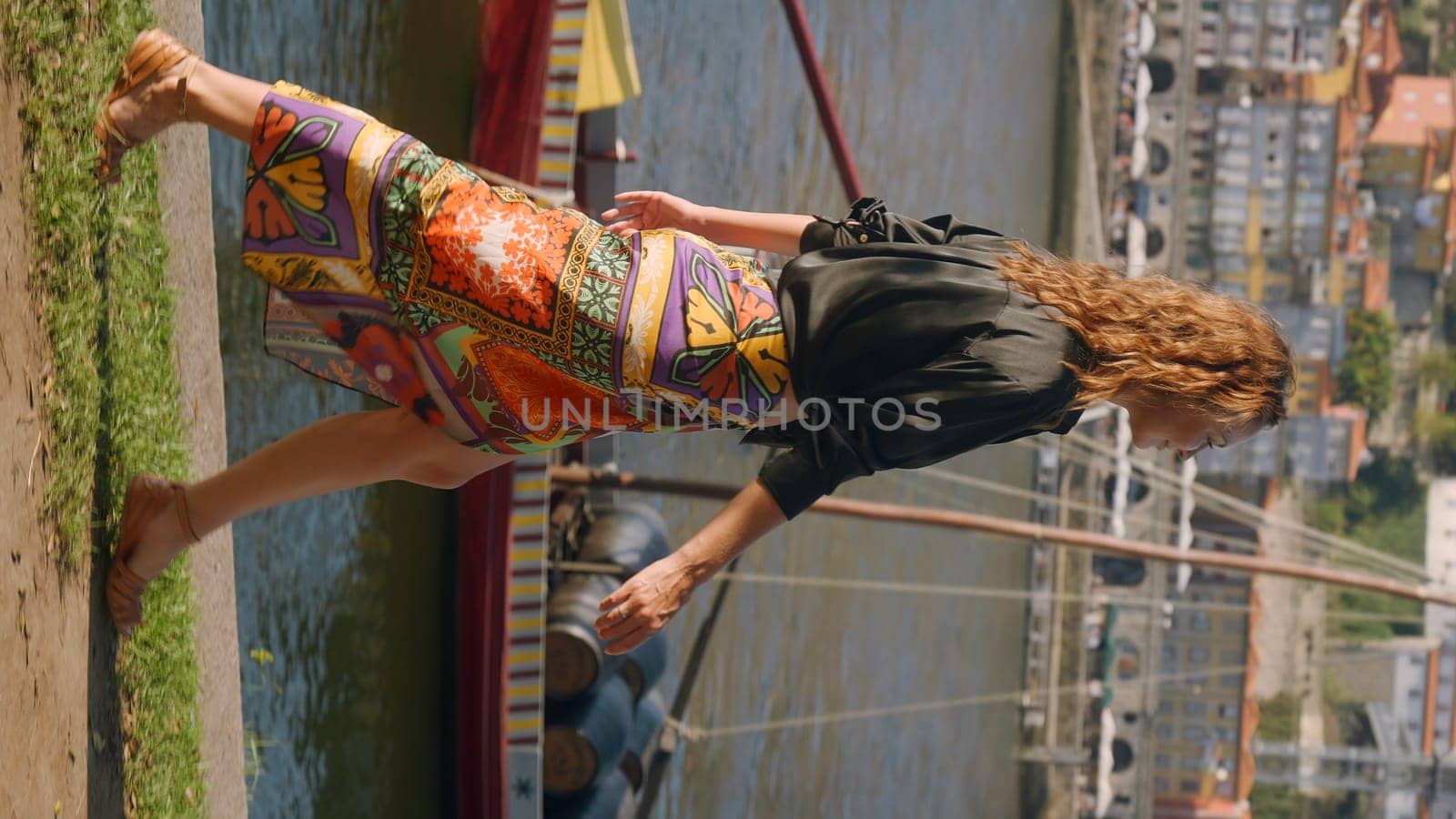 Attractive woman walks on canal embankment in summer. Action. Beautiful woman in skirt sexually walks along embankment. Video for vertical story from summer vacation by Mediawhalestock