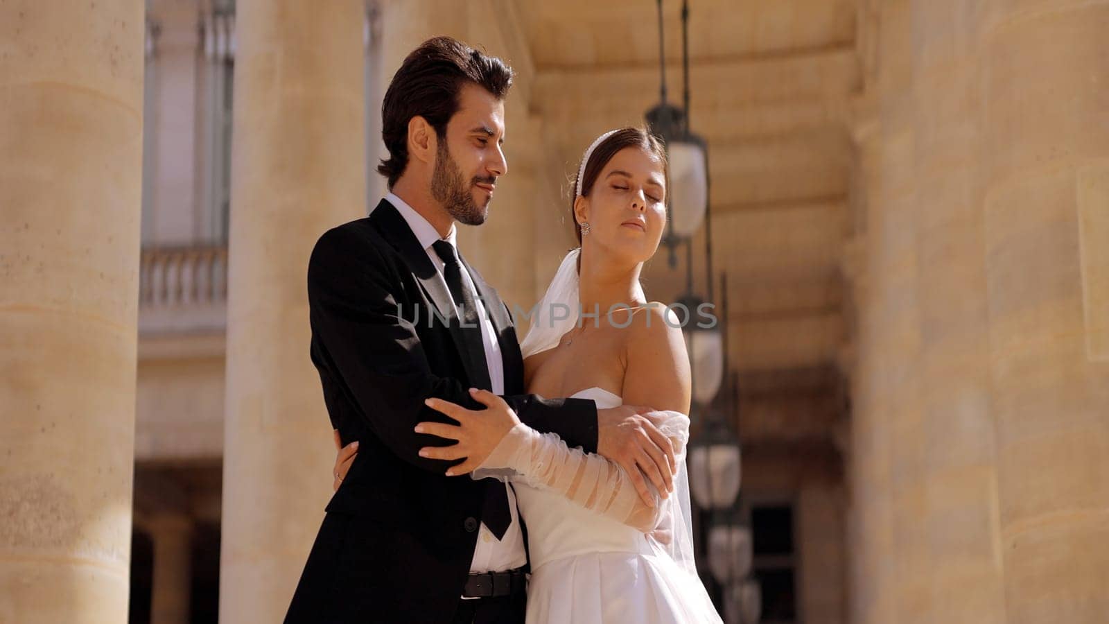 Loving newlyweds posing on their wedding day. Action. Young and elegant man in suit and woman in white dress