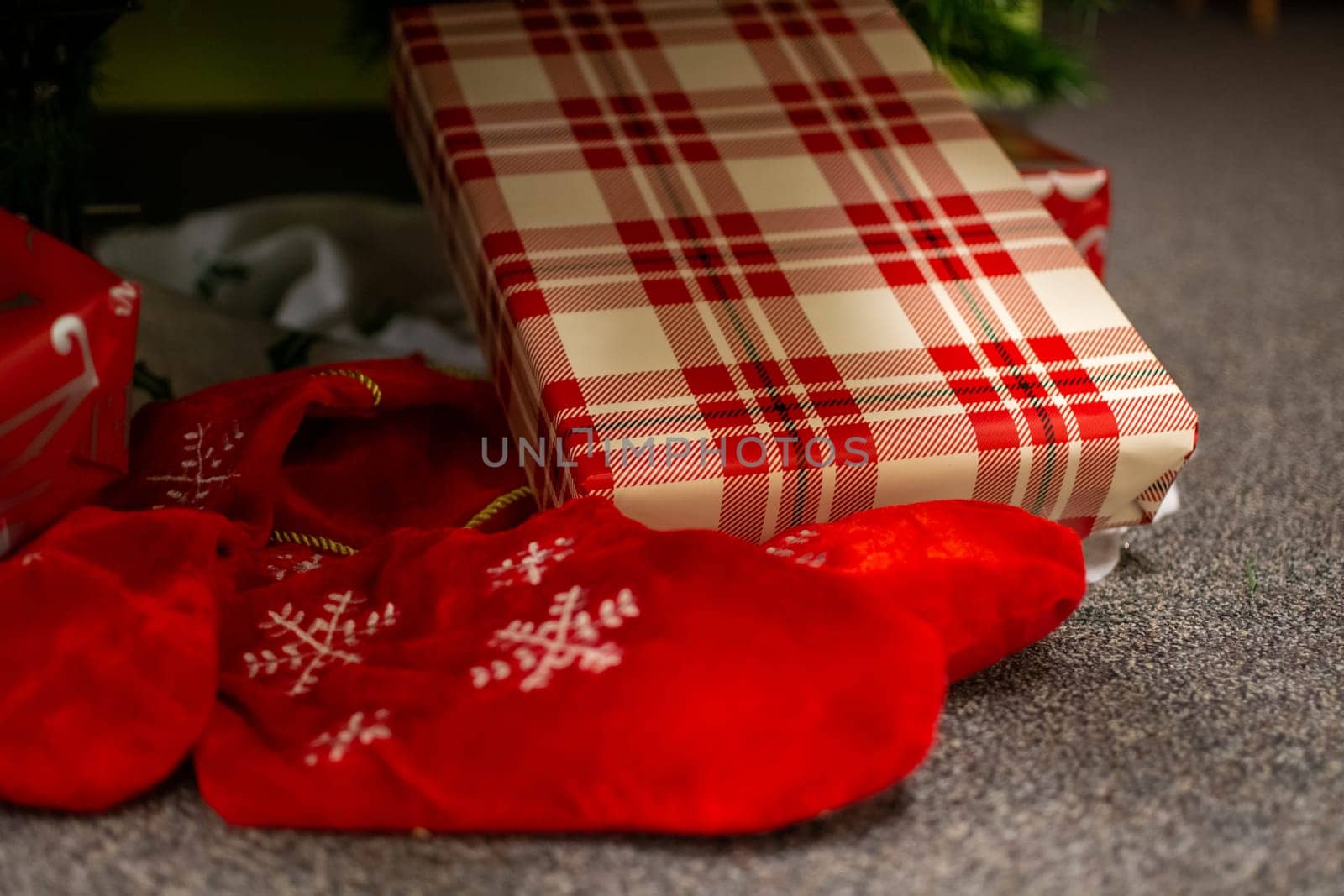 Christmas gifts laying on the floor under fir tree branches