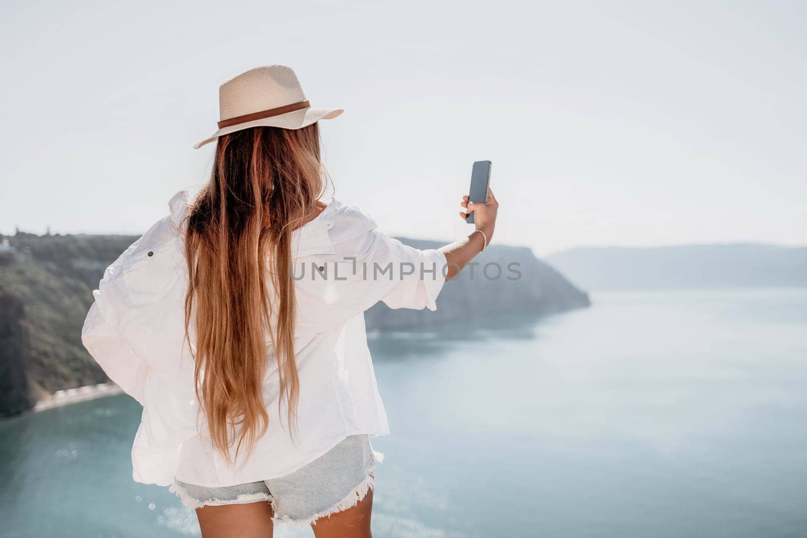 Woman sea laptop. Business woman in yellow hat freelancer with laptop working over blue sea beach. Girl relieves stress from work. Freelance, digital nomad, travel and holidays concept by panophotograph