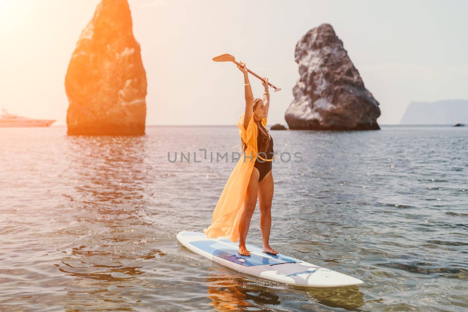 Woman sea sup. Close up portrait of happy young caucasian woman with long hair looking at camera and smiling. Cute woman portrait in bikini posing on sup board in the sea by panophotograph