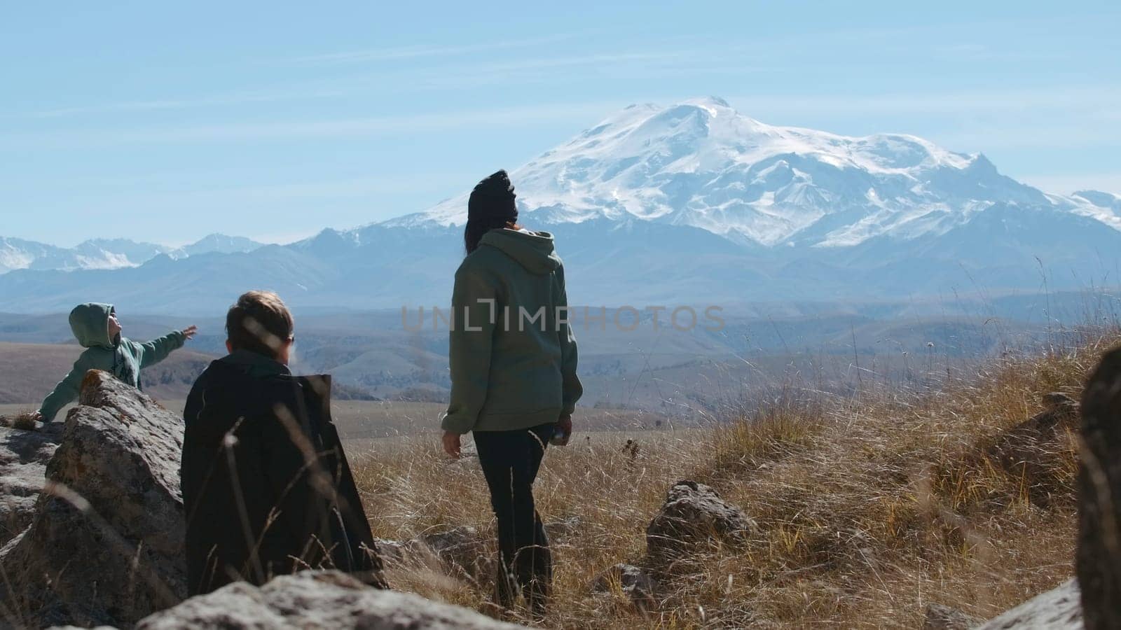 Carefree happy family hikers on mountain top on summer trip adventure. Creative. Family travel in mountainous region. by Mediawhalestock