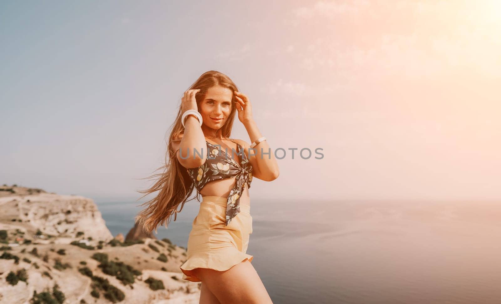 Woman travel sea. Happy tourist taking picture outdoors for memories. Woman traveler looks at the edge of the cliff on the sea bay of mountains, sharing travel adventure journey by panophotograph