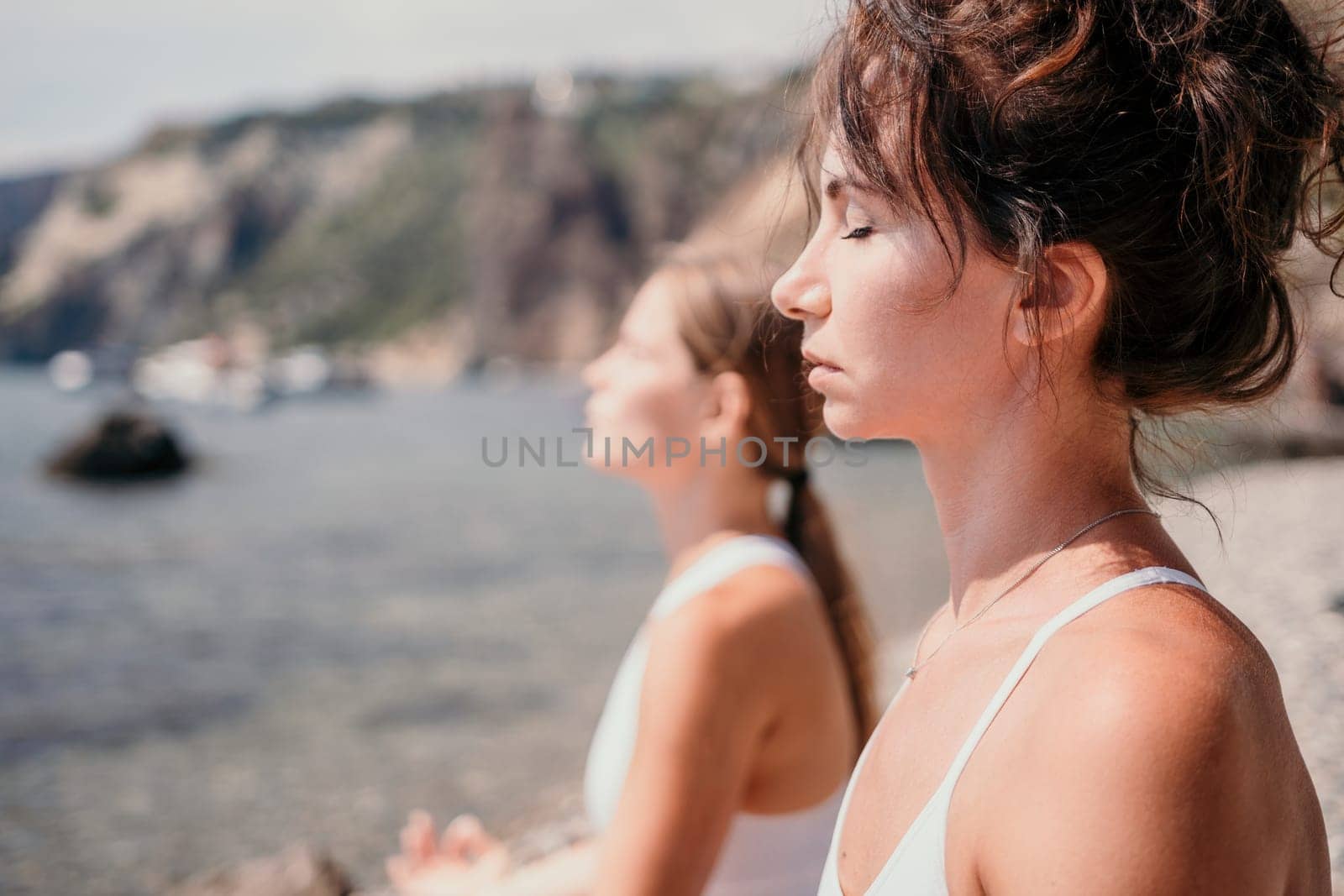 Woman sea yoga. Back view of free calm happy satisfied woman with long hair standing on top rock with yoga position against of sky by the sea. Healthy lifestyle outdoors in nature, fitness concept.