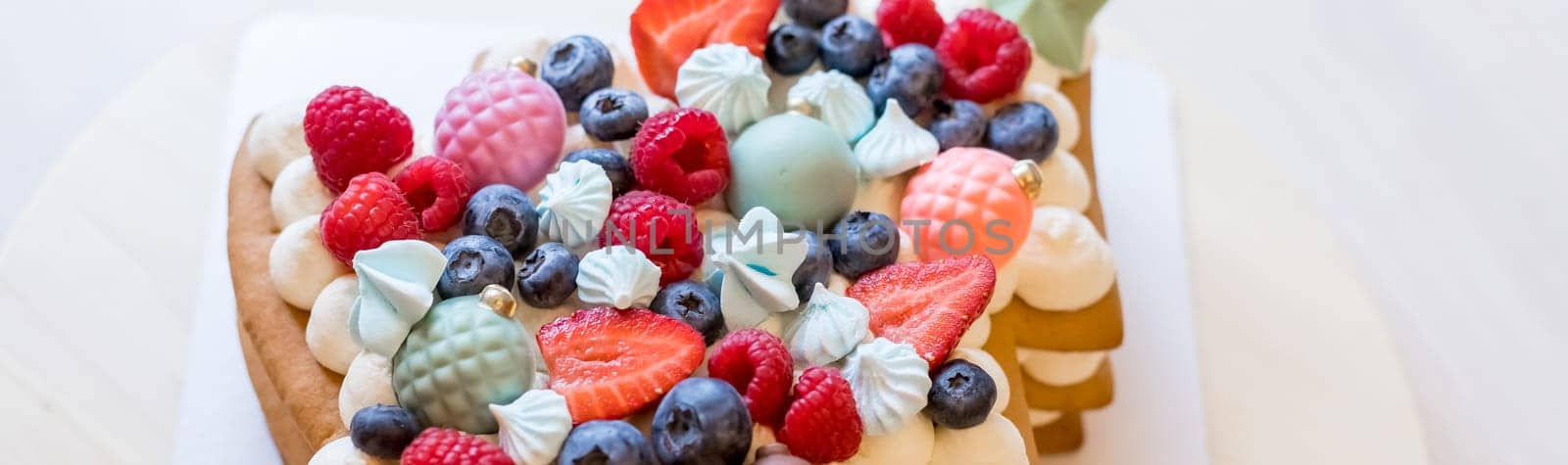 Homemade naked layered vanilla cake with whipped cream and fresh berries on top on a gray concrete background. Summer cake. Copy space