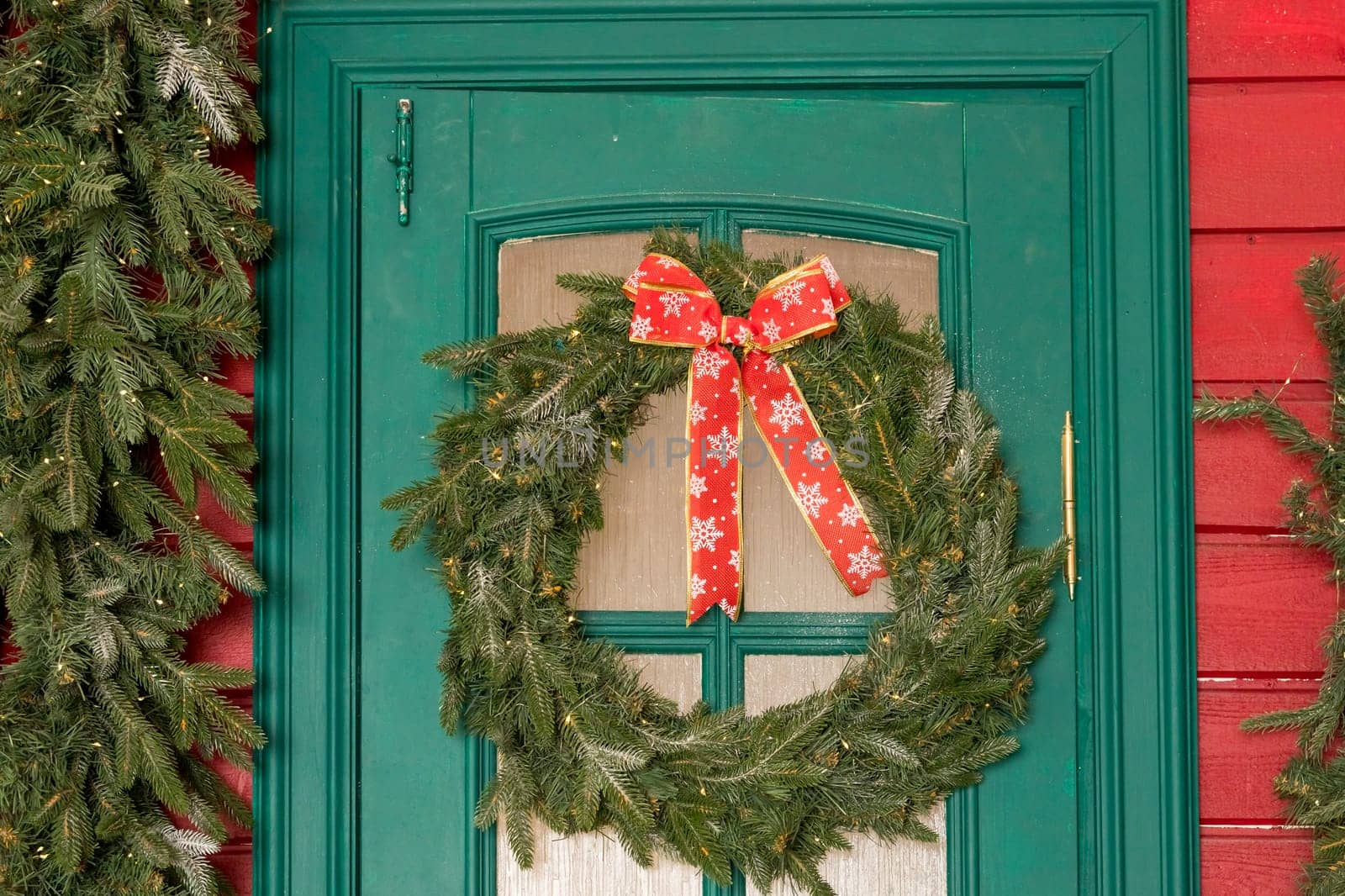 Wreath decoration at door for Christmas holiday.Traditional christmas wreath on old wooden green door in european city street. Stylish christmas street decor, Winter holidays by YuliaYaspe1979