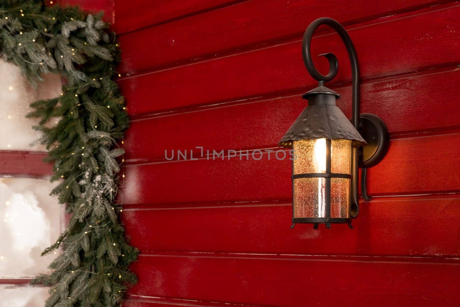 Old Christmas lantern on wooden wall background.Street lantern decorated for Christmas, burning iron black lantern by YuliaYaspe1979