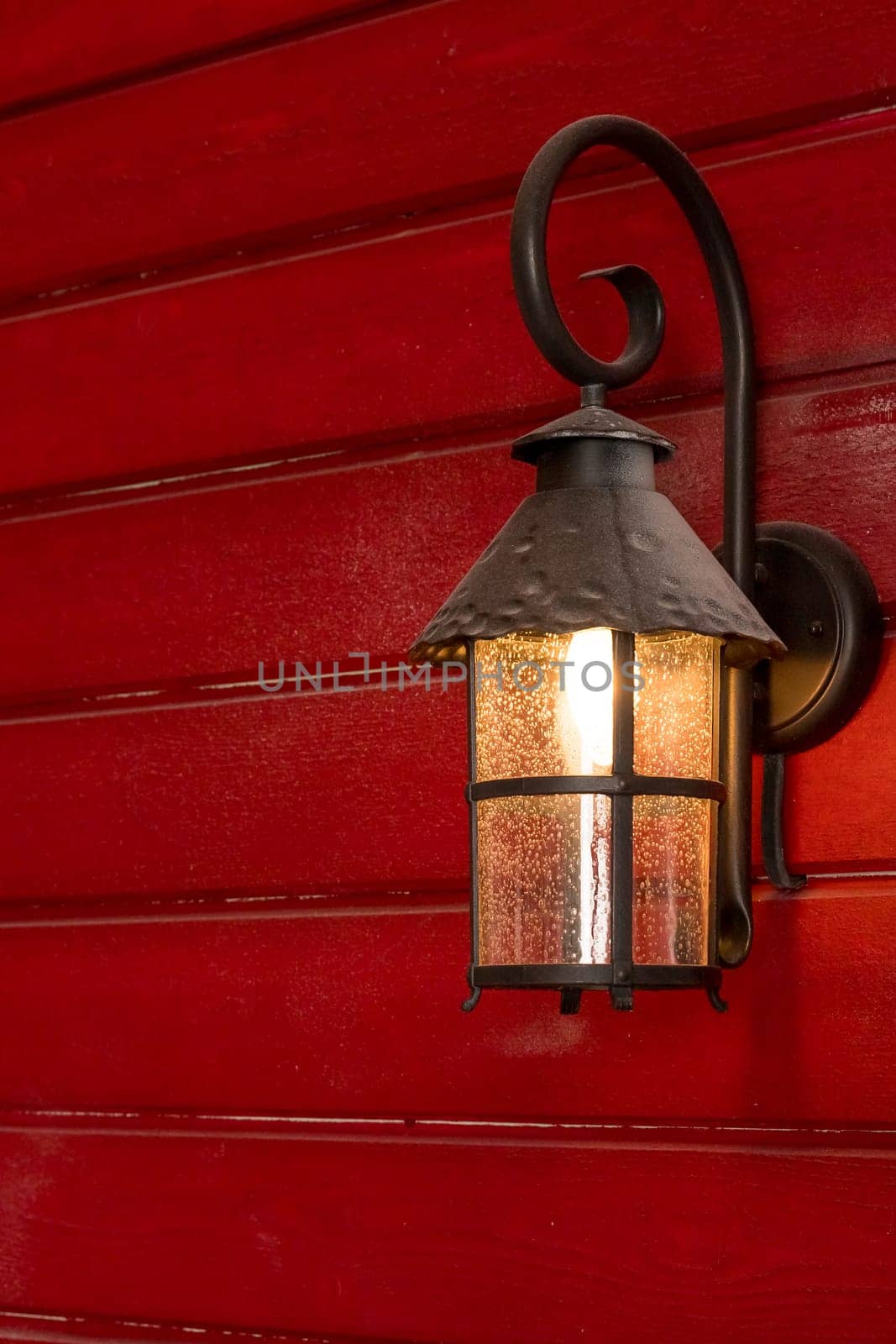 Old Christmas lantern on wooden wall background.Street lantern decorated for Christmas, burning iron black lantern by YuliaYaspe1979