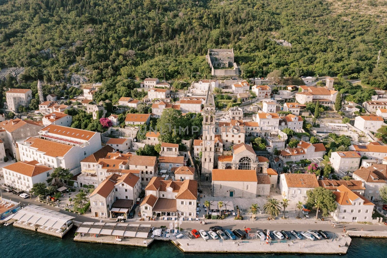 Parking lot on the embankment overlooking the Church of St. Nicholas. Perast, Montenegro. Drone. High quality photo