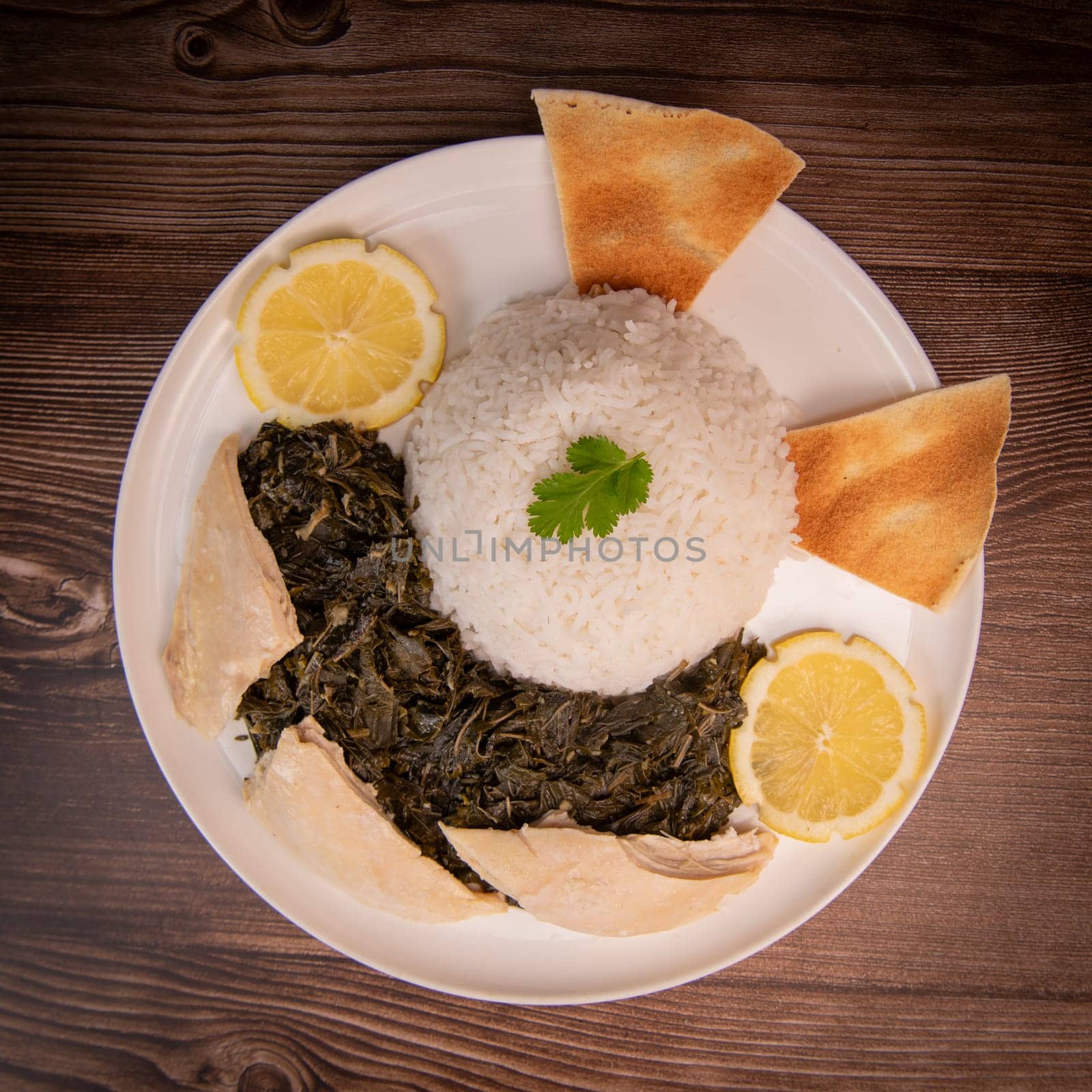 Lebanese recipe Mouloukhia , Melokhiyah, corete leaf and coriander rice chicken, grilled pita. High quality photo