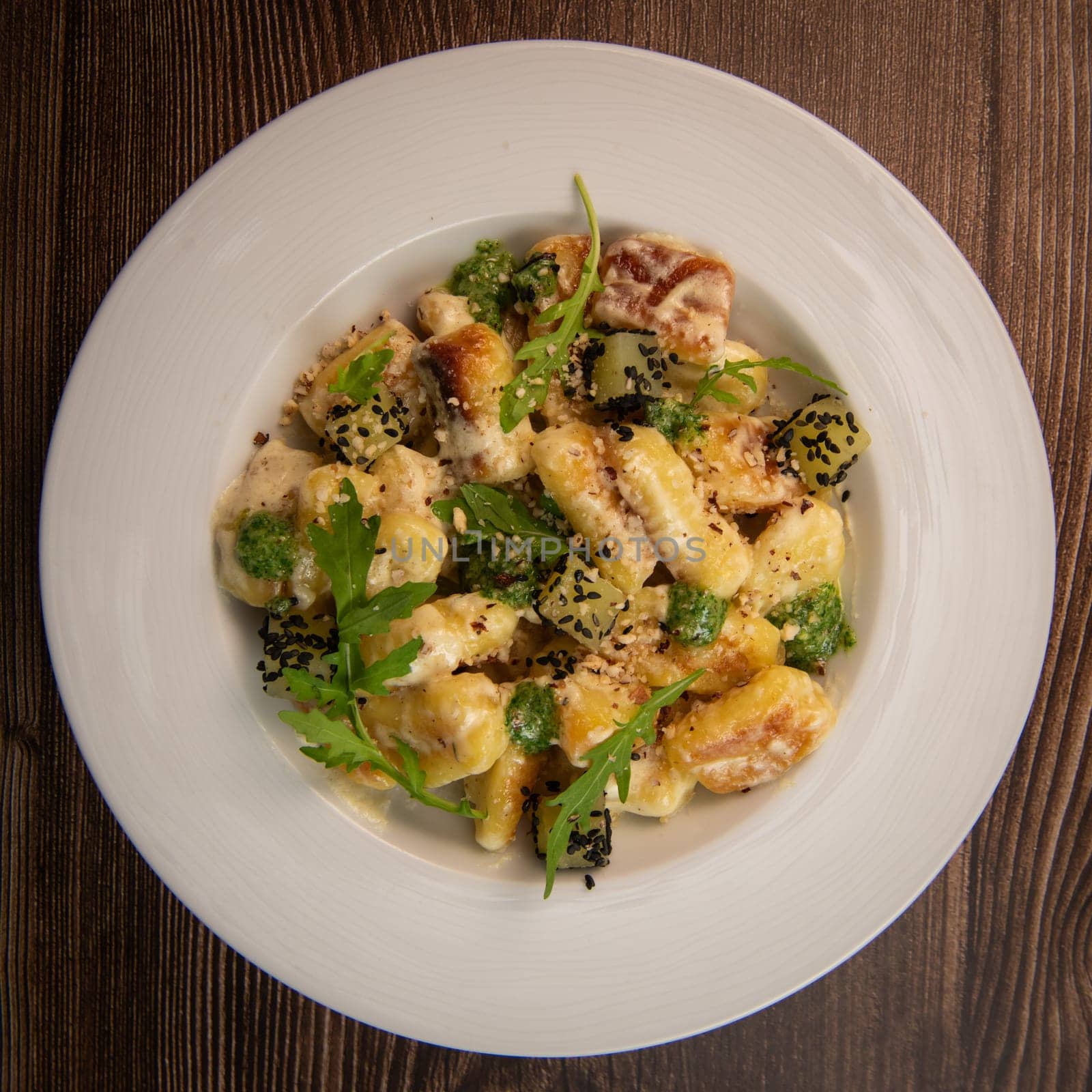 RECIPE FOR POTATO GNOCCHI WITH ROCKET SALAD PESTO AND CREAMY PARMESAN SAUCE. High quality photo