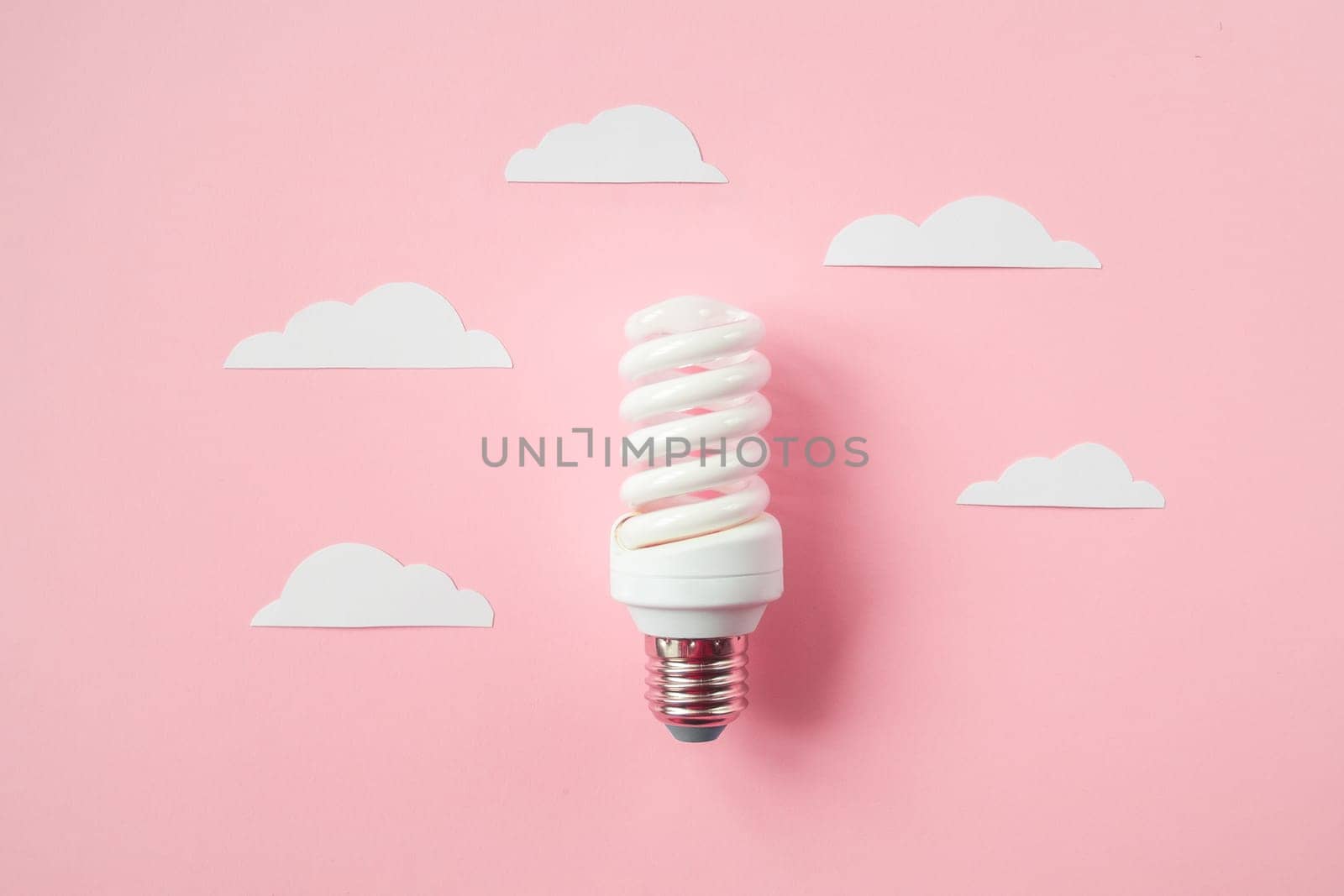 Light bulb with white cut out clouds on pink background. Idea concept. Energy and electricity. alternative energy sources. Innovation and thinking out the box symbols. Creativity and inspiration