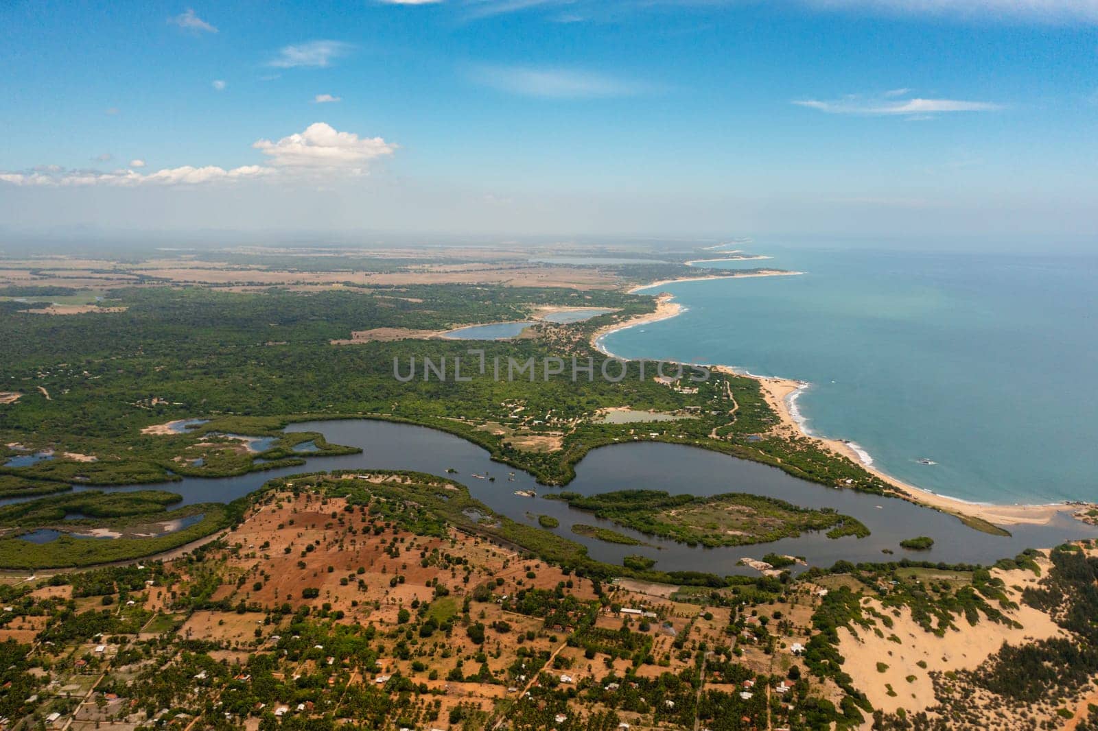 Aerial drone of coastline of Sri Lanka with the ocean and beaches, agricultural lands and towns.