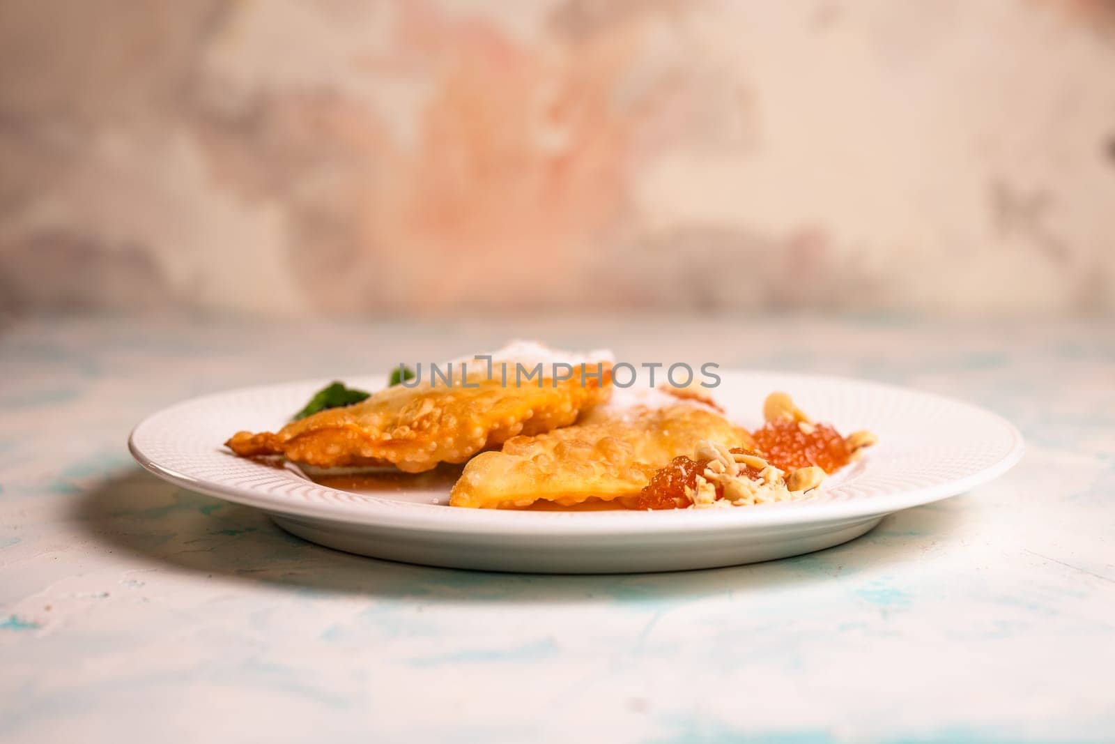 sweet pasties with sugar sprinkles on a white plate.