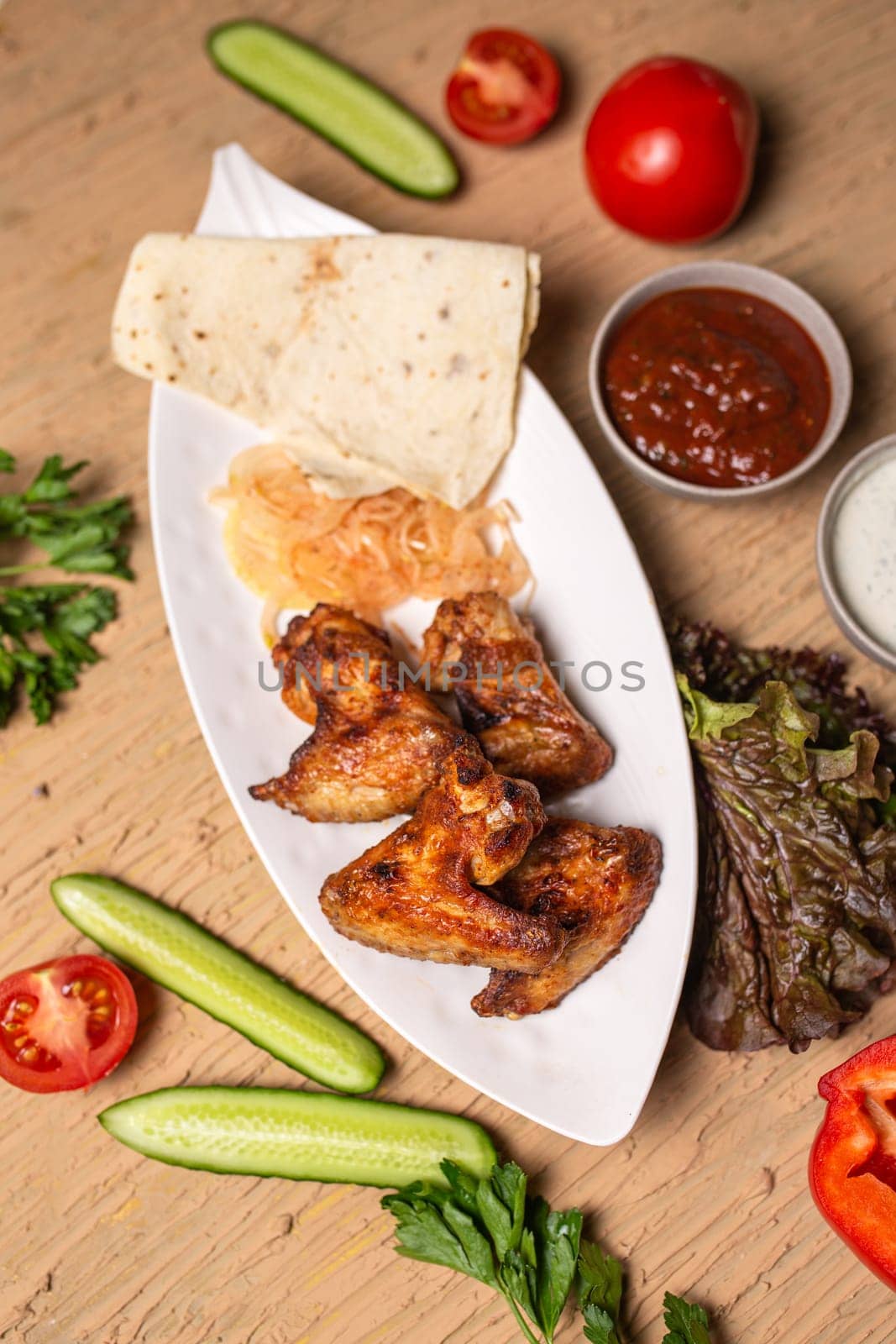 shish kebab of chicken wings on a white plate by Pukhovskiy