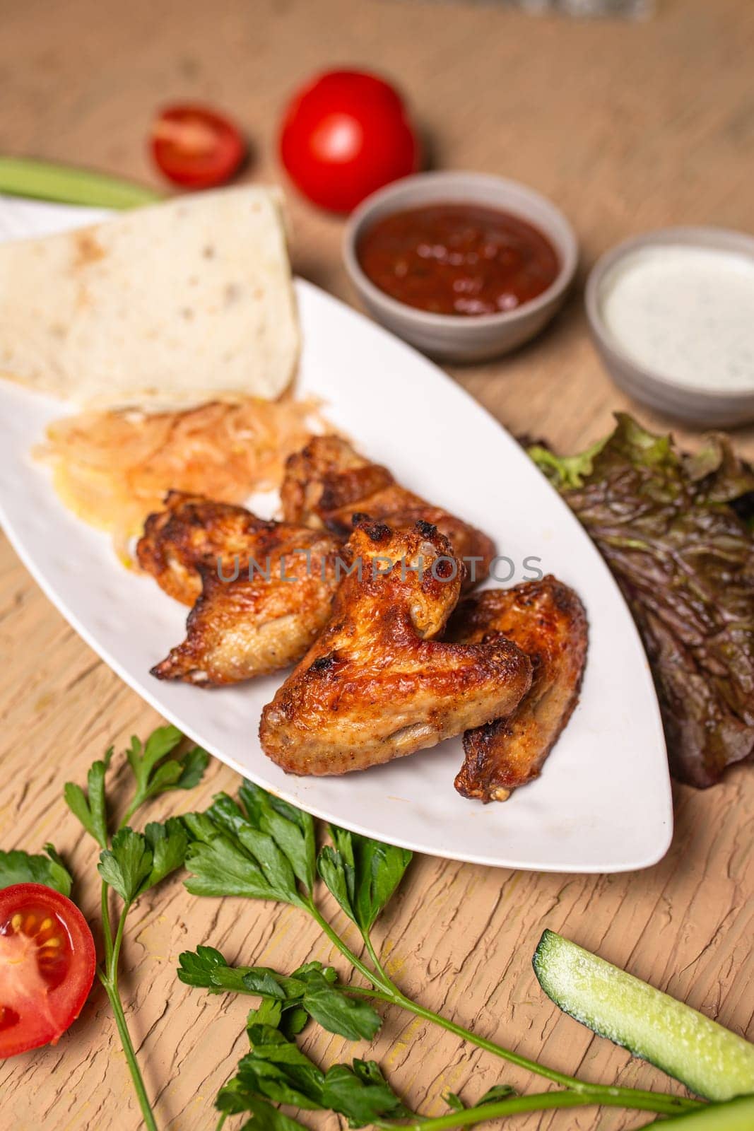 shish kebab of chicken wings on a white plate by Pukhovskiy