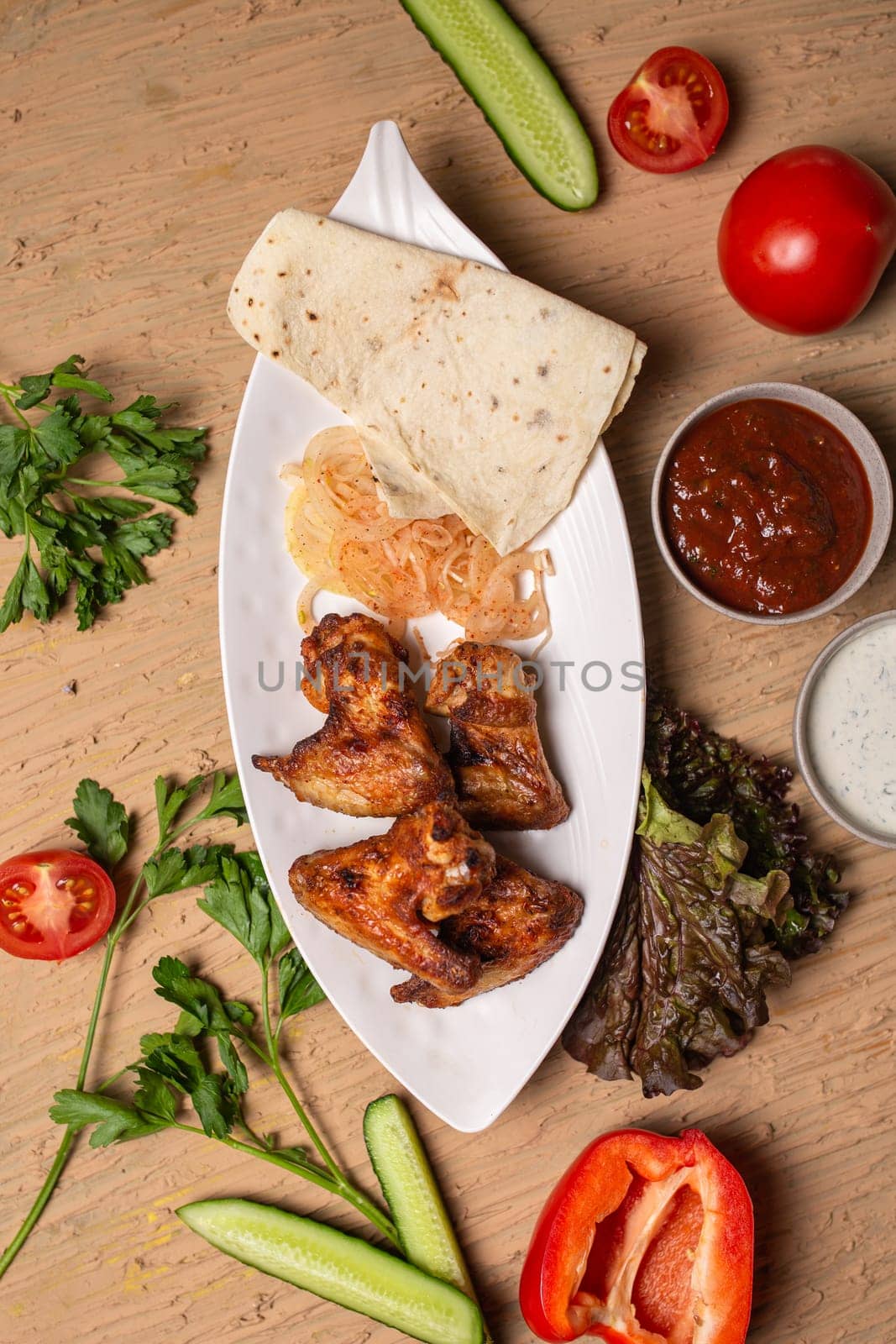 shish kebab of chicken wings on a white plate.