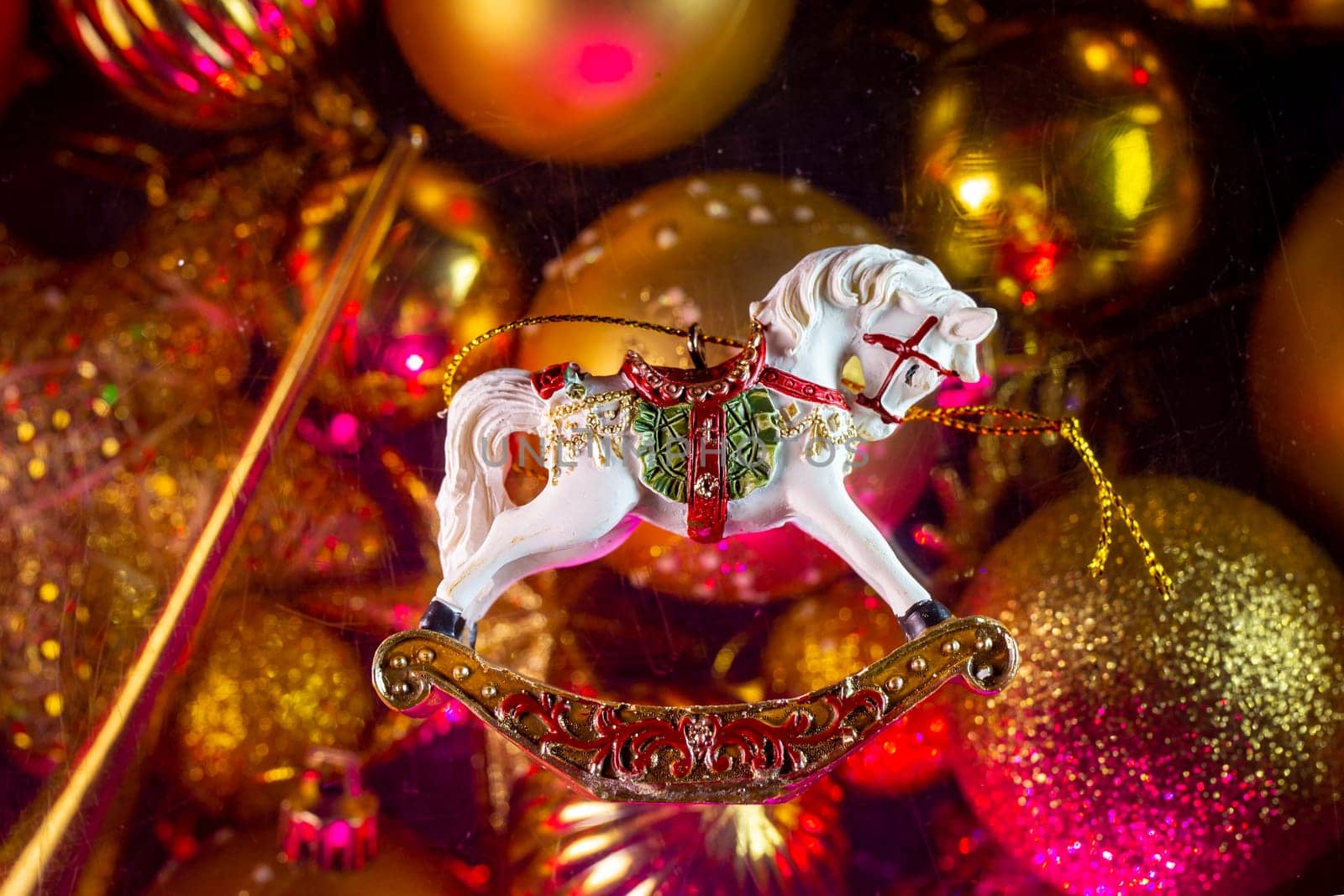 christmas toy horse on the background of toys under artificial lighting.