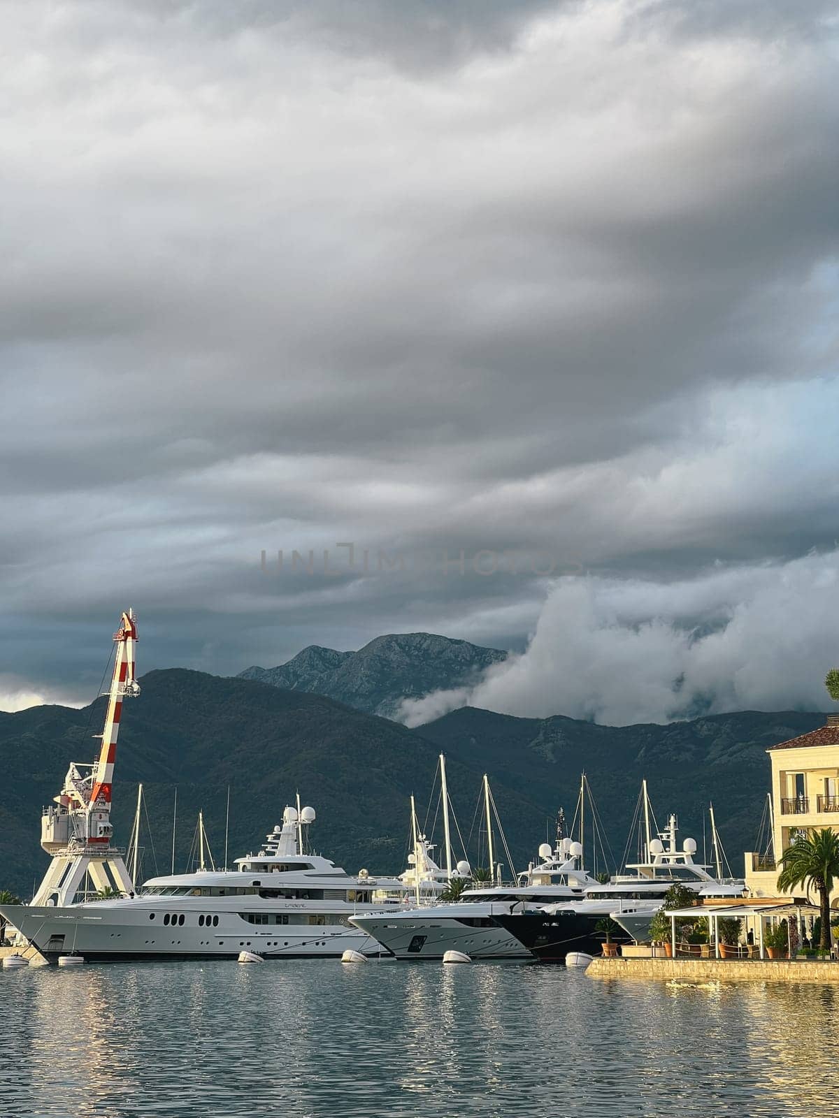Yachts stand at the mooring of the marina against the backdrop of mountains in the fog. High quality photo