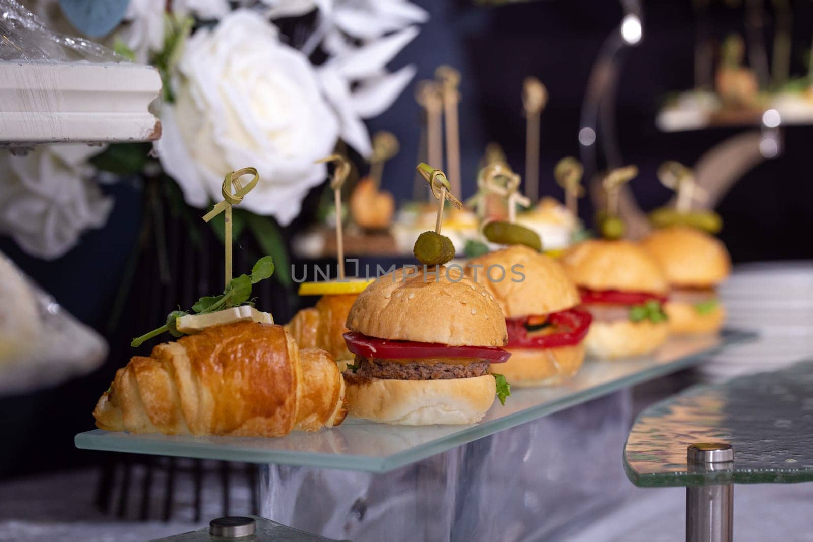 burgers on a stand on the buffet table.