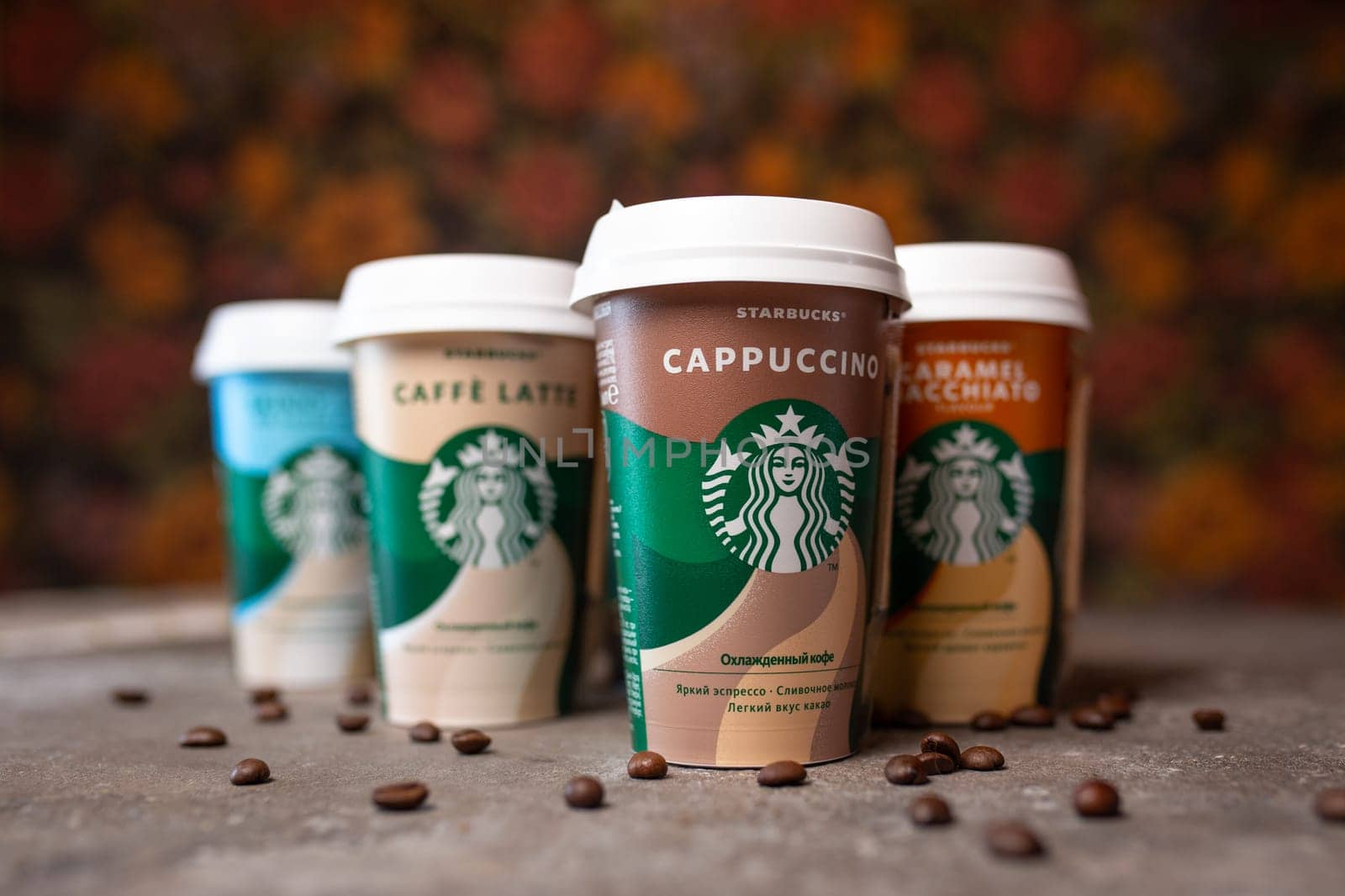 starbucks coffee in cups in assortment on the table with coffee beans