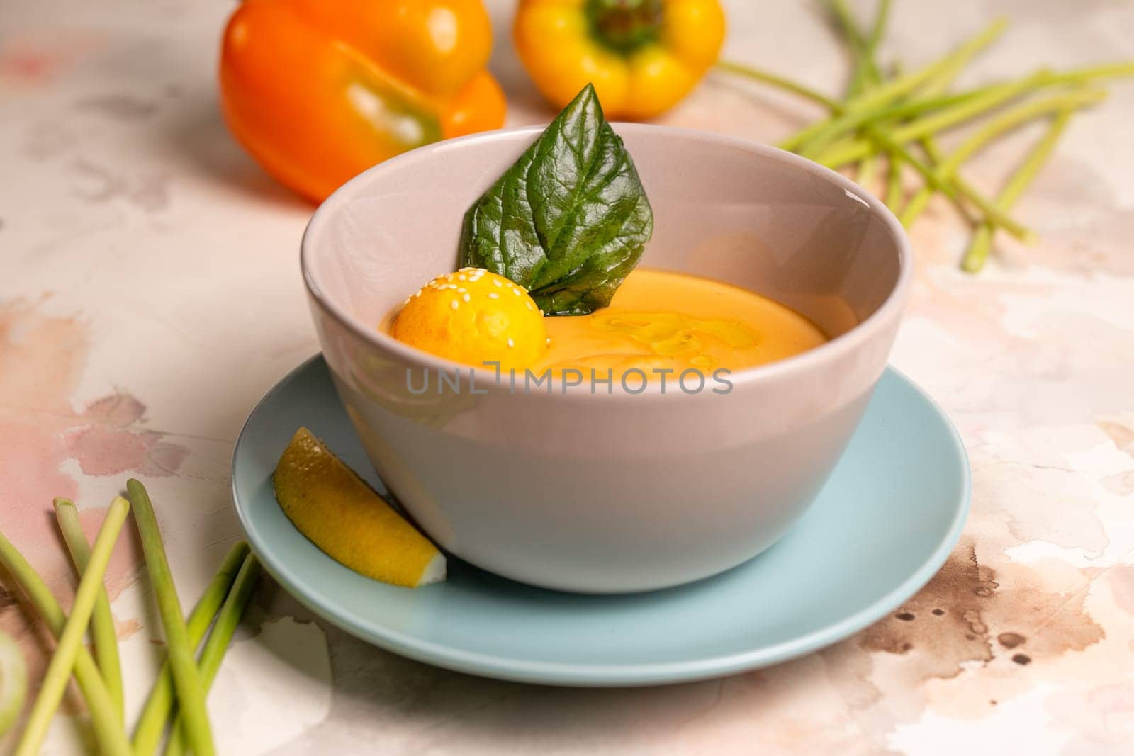 pumpkin cream soup with a slice of lemon in a plate on the table by Pukhovskiy