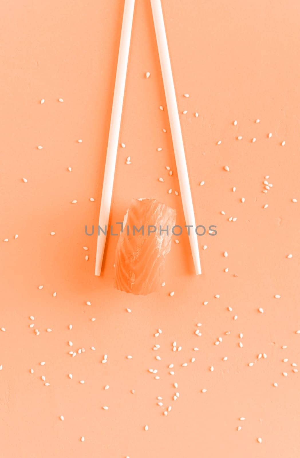 Color of the year 2024: Peach Fuzz. Minimal concept. sushi with salmon and chopsticks, isolated on background. Top view. Flat lay