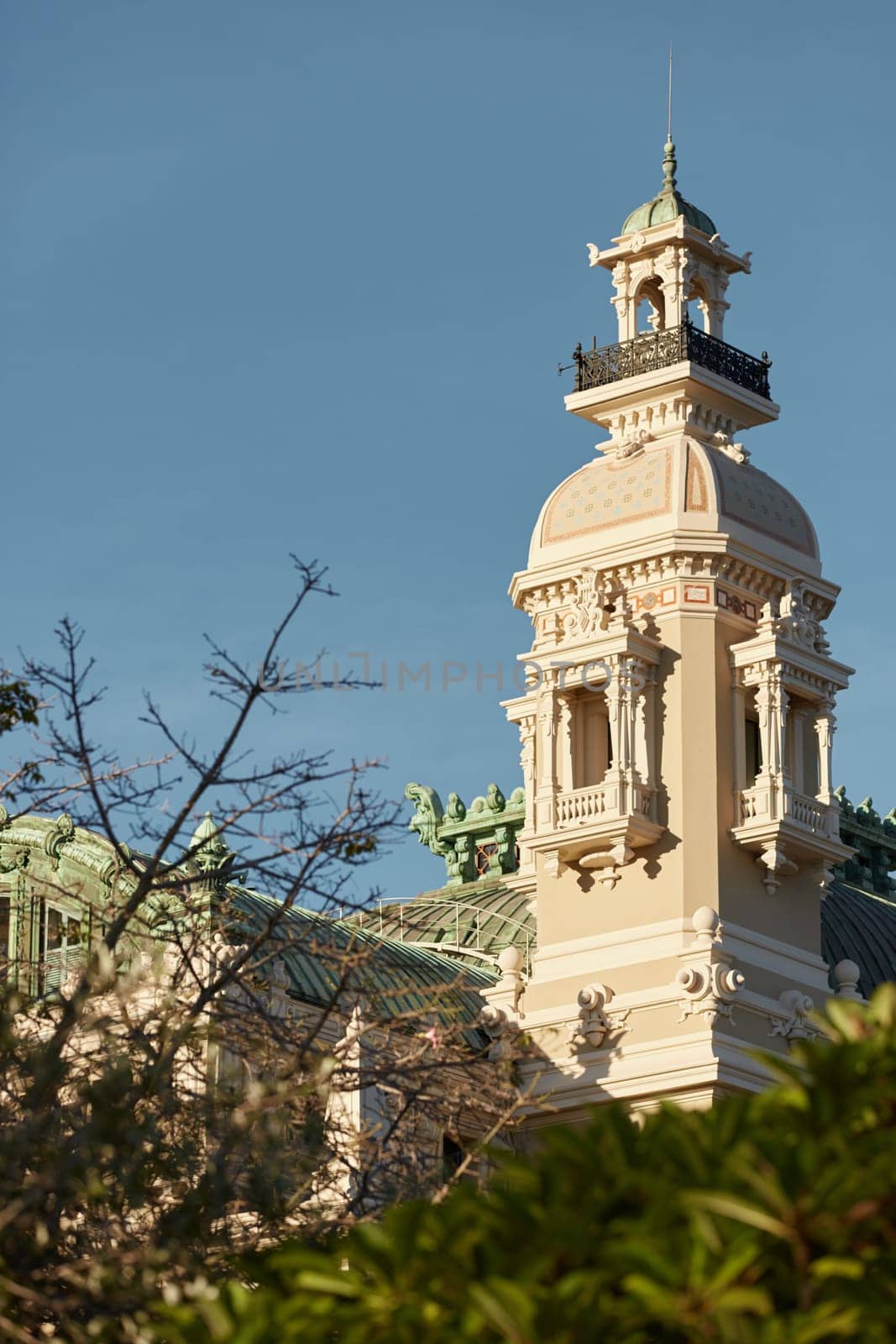 Monaco, Monte-Carlo, 21 October 2022: Tower of Casino Monte-Carlo at sunset, wealth life, famous landmark, pine trees, blue sky. High quality photo