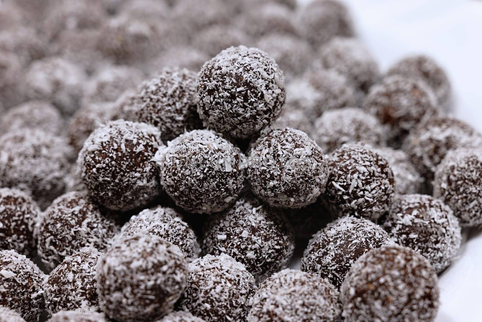 Rum balls in coconut. Traditional unbaked Czech sweets for Christmas and winter. Raw sweet food with cocoa and coconut. by Montypeter