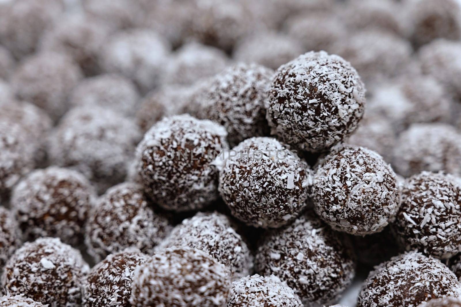 Rum balls in coconut. Traditional unbaked Czech sweets for Christmas and winter. Raw sweet food with cocoa and coconut.