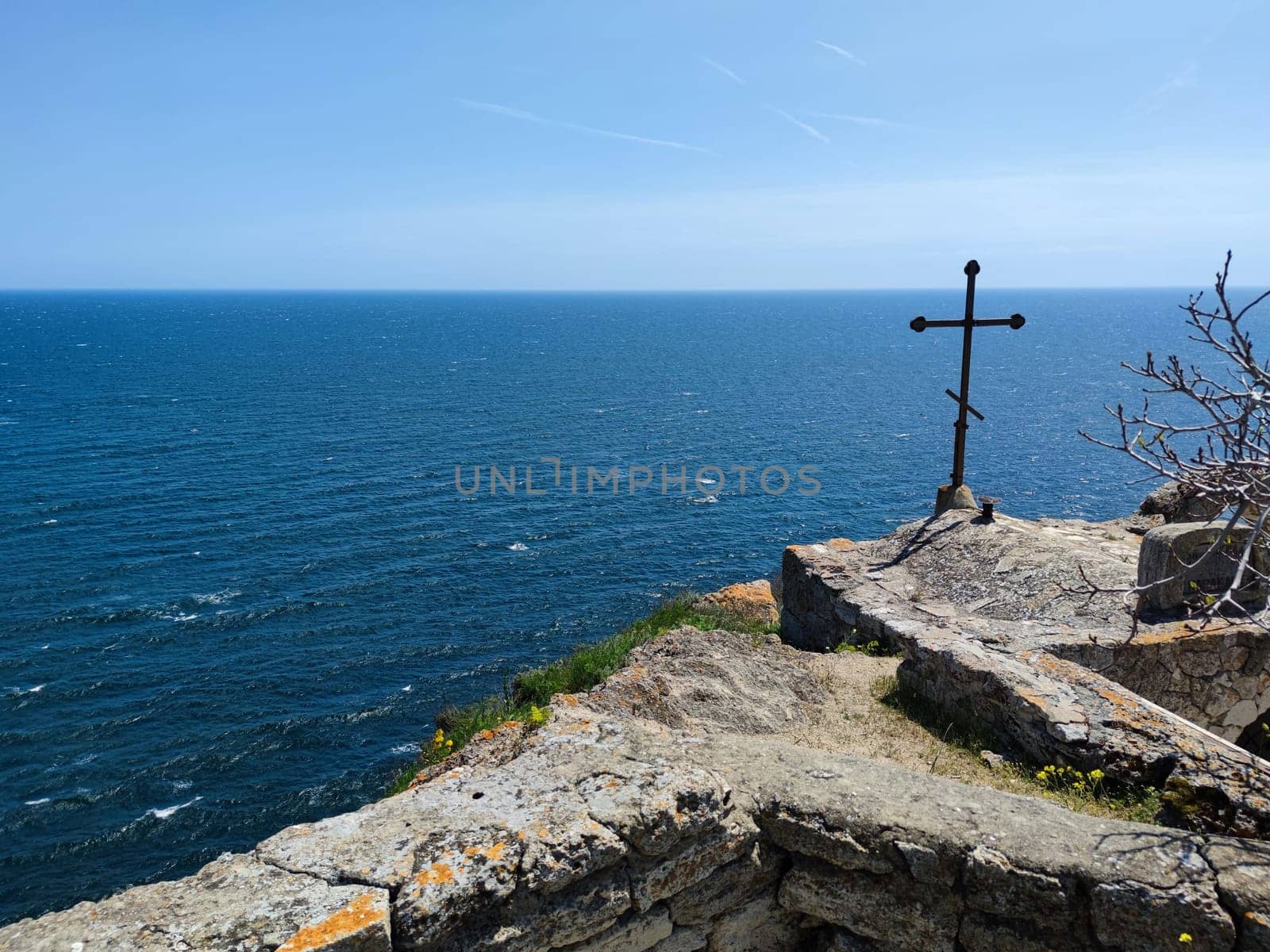 metal cross on top of Cape Kaliakra in Bulgaria against the sea horizon by Annado