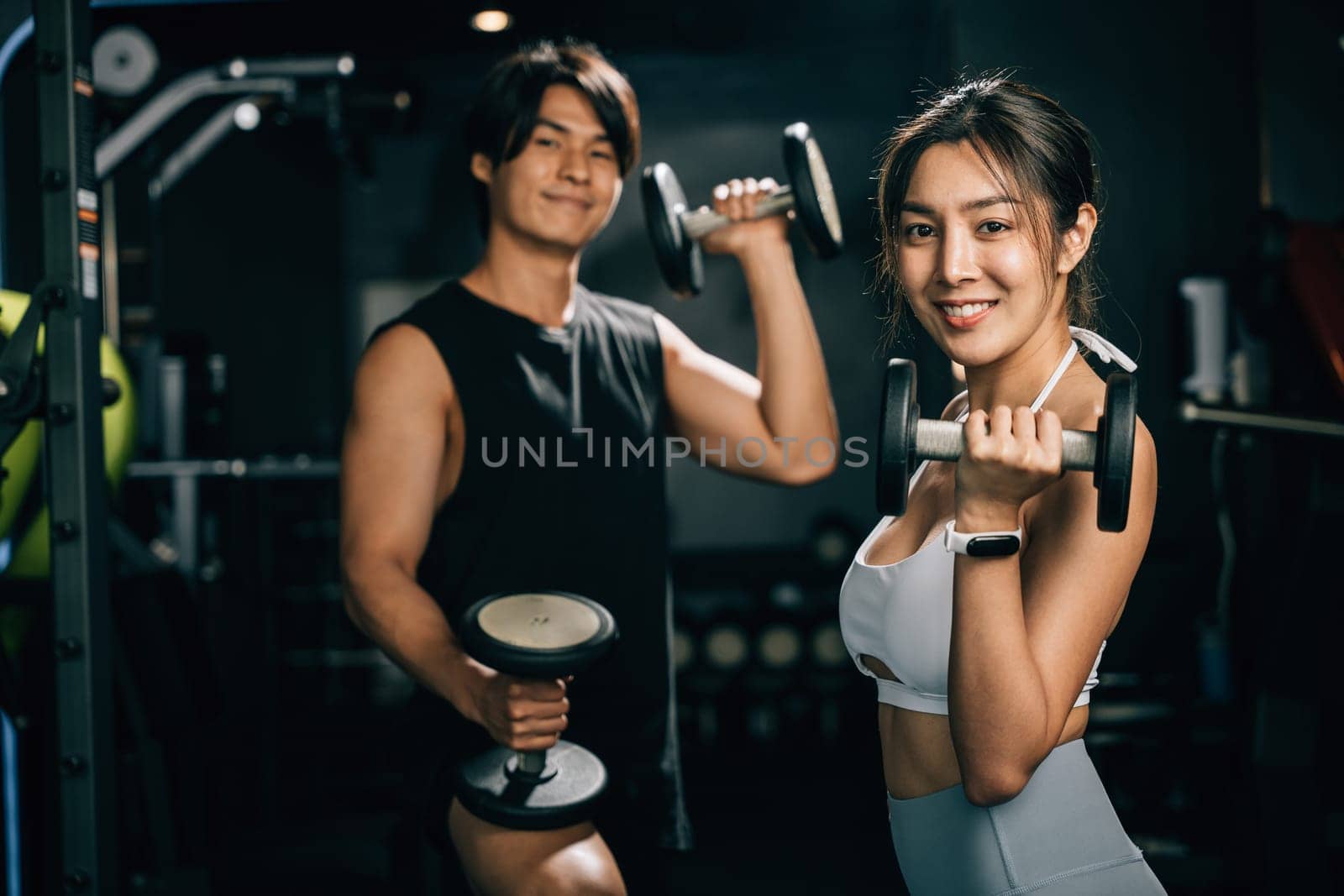 A strong and sexy man, holding a weight dumbbells and looking into the distance, showcases his muscular bicep and athletic body for a fitness portrait. lifestyle fitness concept