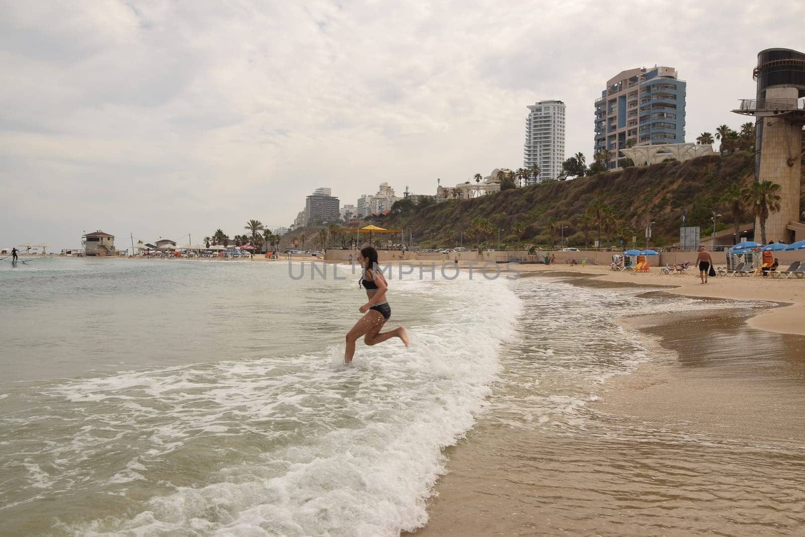 20 June 2023 Netanya Israel, beach sand and sea water, women go,summer . High quality photo