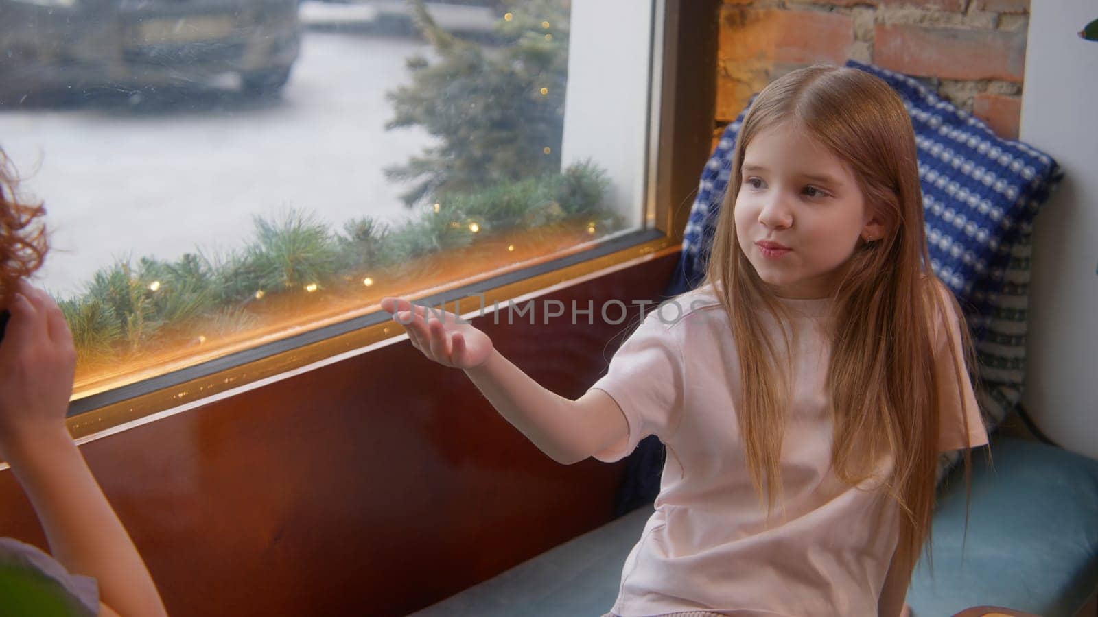 Boy and girl are talking in cafe. Stock footage. Cute couple of kids are sitting in cafe. Children chat sweetly together in cafe. Childhood infatuation.