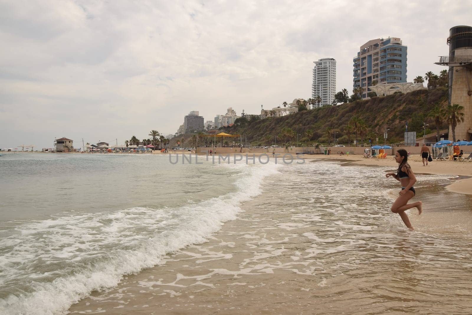 20 June 2023 Netanya Israel, beach sand and sea water, women go,summer . High quality photo