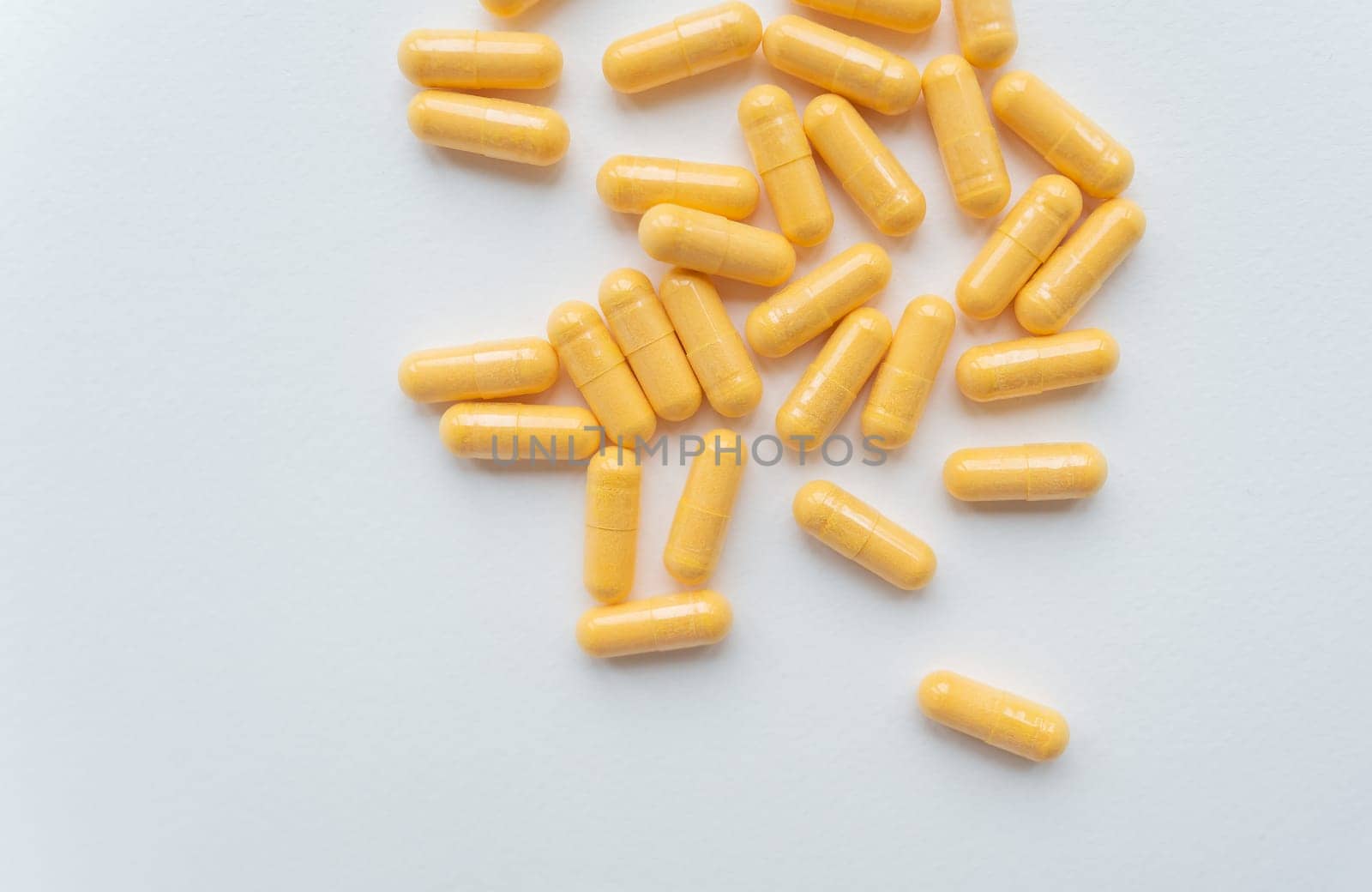 The image shows yellow capsules on a light grey background, suitable for healthcare and pharmaceutical themes