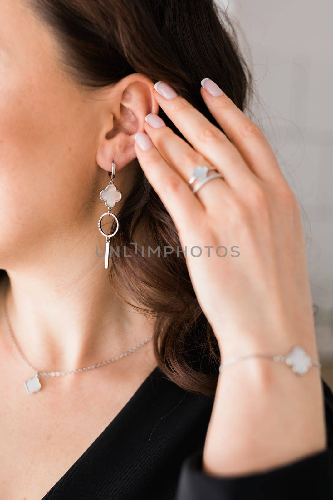 Detail of young woman wearing beautiful luxury earring and bracelet. Handmade jewellery and accessories by Satura86