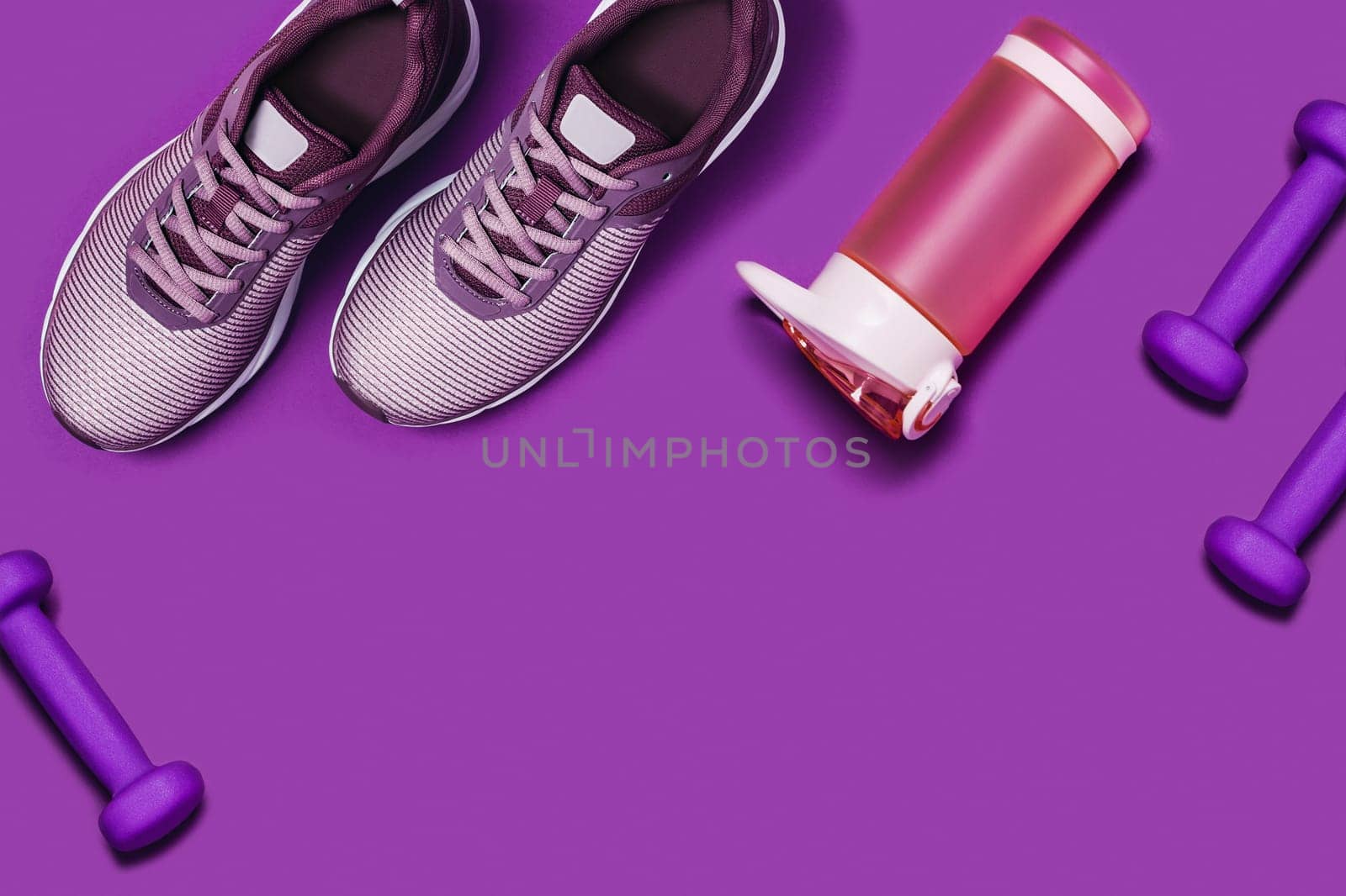 Purple sports background with sneakers, dumbbels and shaker. Flat lay picture.