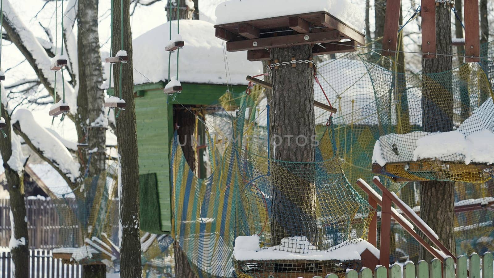 Winter playground. Action.Winter landscape with bright grids for children where a little boy climbs who has fun and crawls on a special web. High quality 4k footage