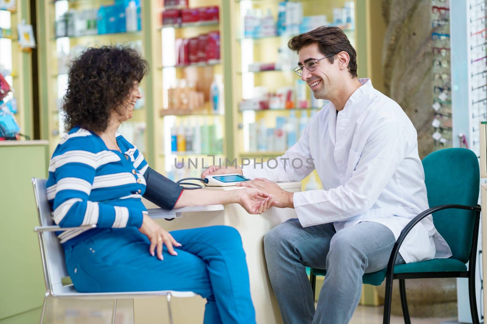 Cheerful druggist and woman customer in pharmacy by javiindy