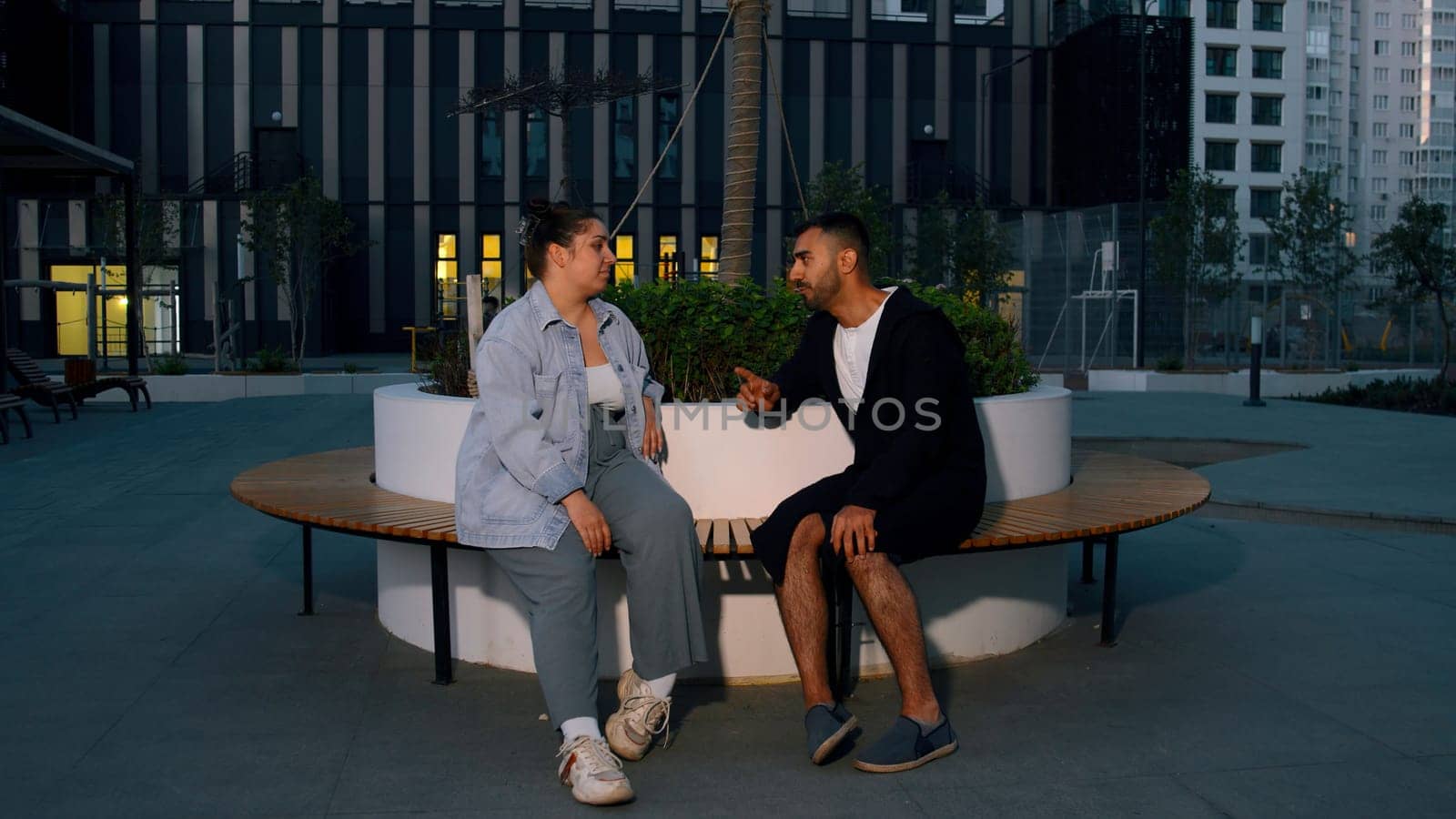 Young couple on park bench having a conversation. Media. Man and woman feeling awkward on their first date