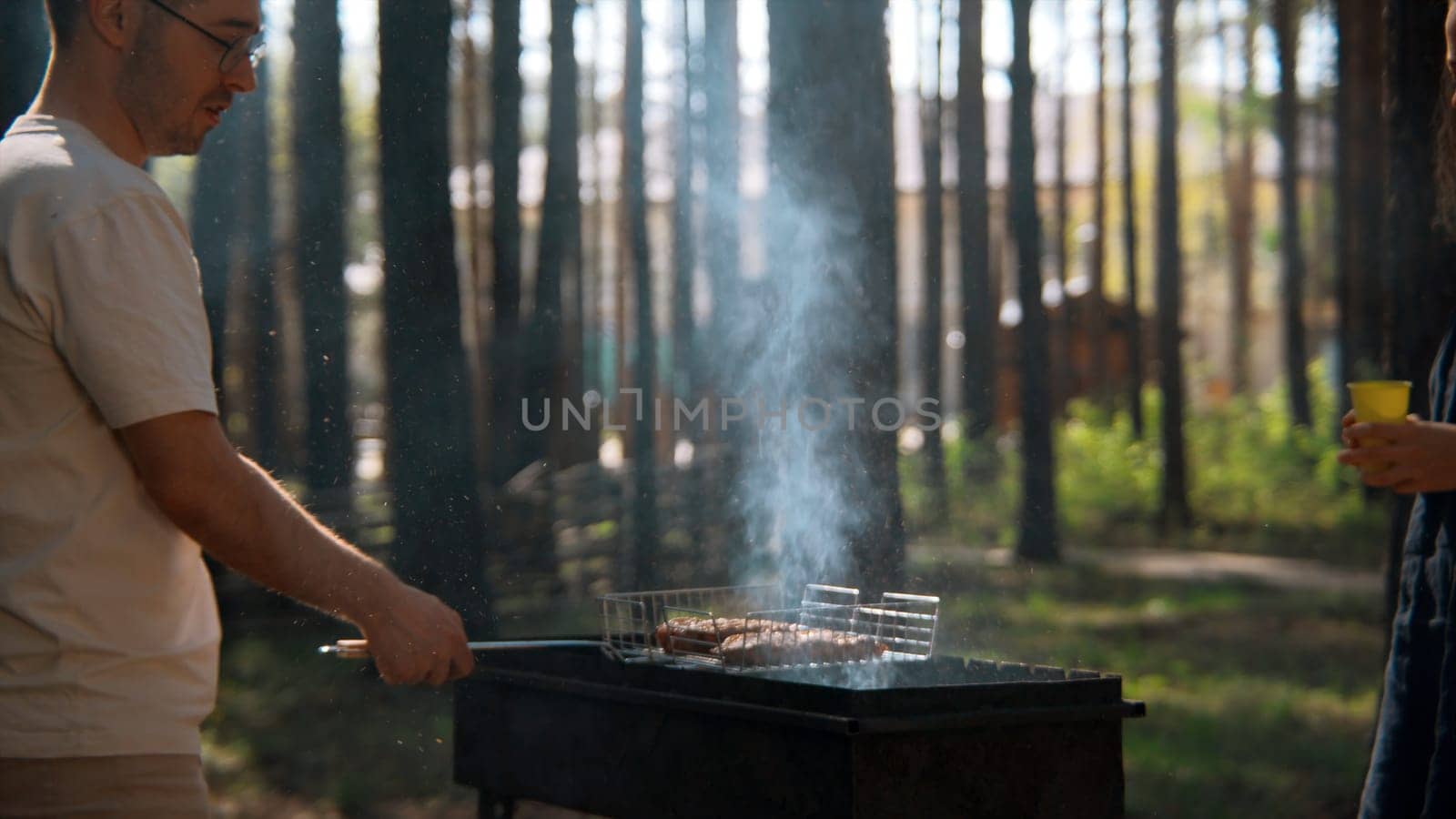 Young adult friends spending time outdoors in autumn forest. Stock footage. Barbeque with friends