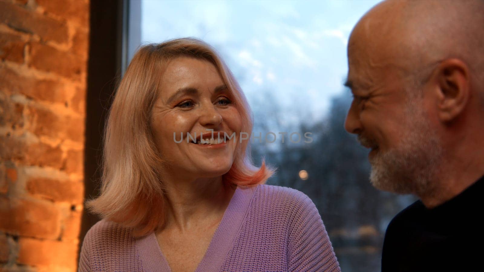 Happy middle aged mature couple talking to each other at the restaurant in the evening. Stock footage. Concept of marriage and long lasting romantic relationships. by Mediawhalestock