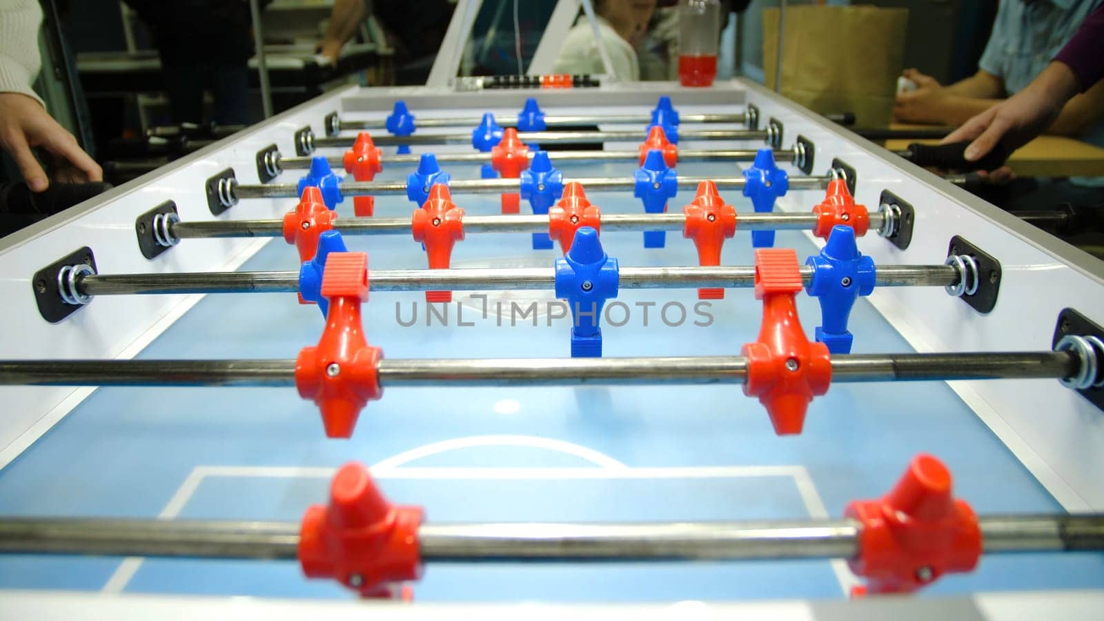 Table football soccer game kicker . Table football game, Soccer table with red and blue players. Young friends playing table football together indoors by Mediawhalestock