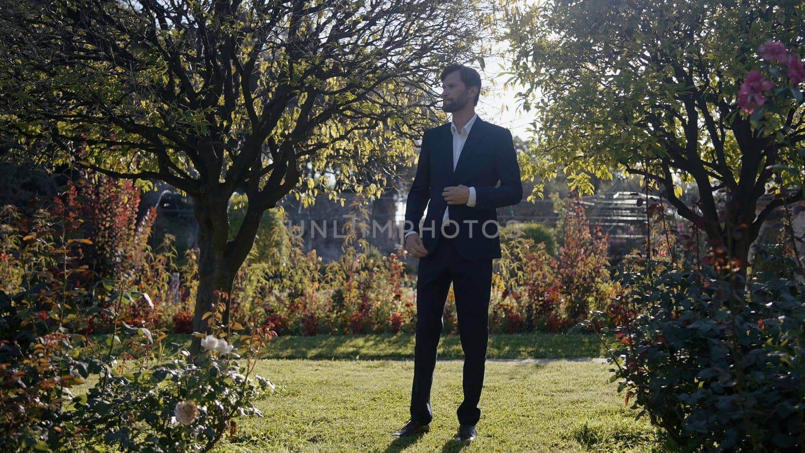 Posing bride and groom. Action.Young people in a summer park with bright flowers and trees pose in wedding dresses separately. High quality 4k footage
