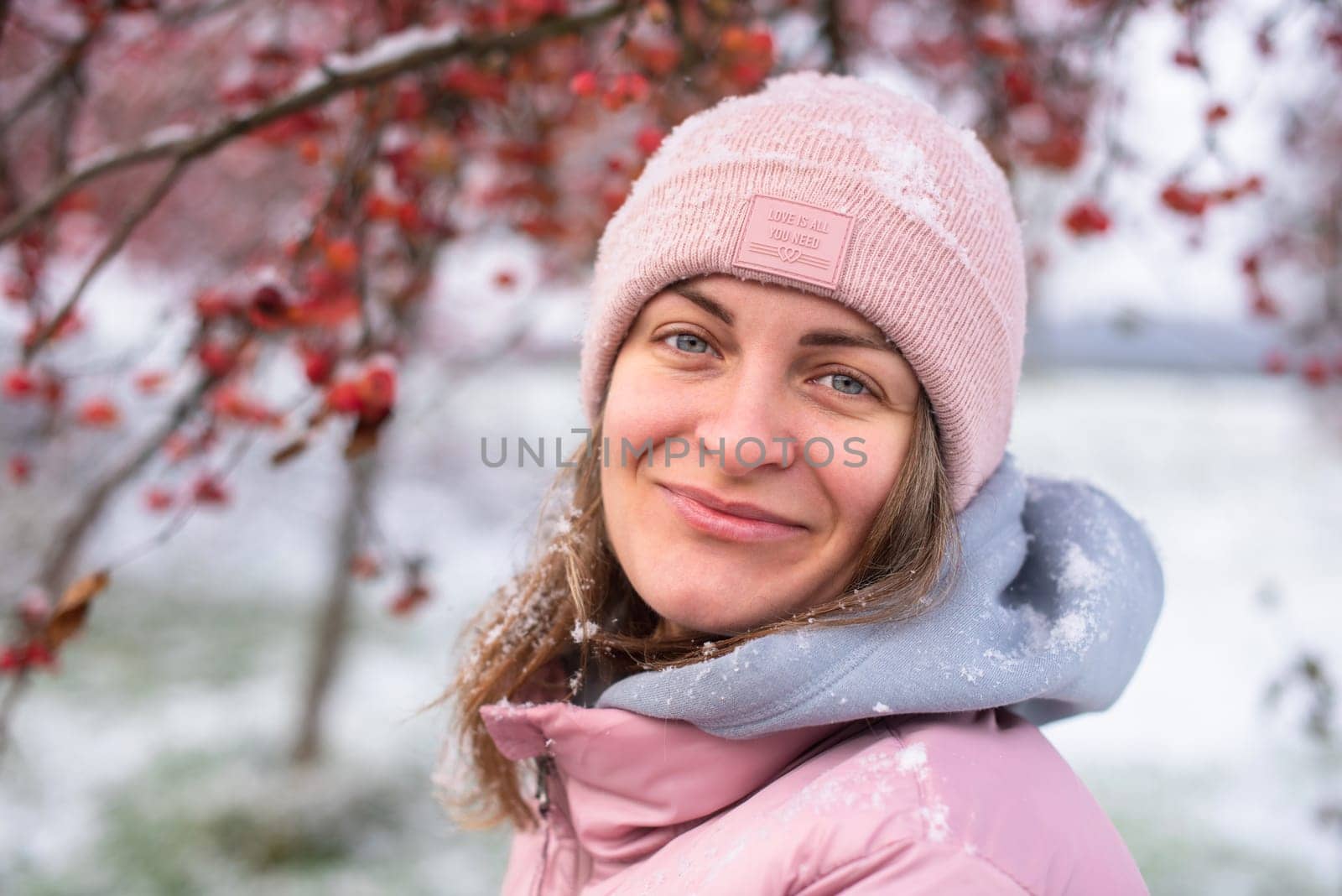 Winter Elegance: Portrait of a Beautiful Girl in a Snowy European Village. Winter lifestyle portrait of cheerful pretty girl. Smiling and having fun in the snow park. Snowflakes falling down. Christmas Radiance: Capturing Winter Elegance in the Snowy Ambiance of a European Village by Andrii_Ko